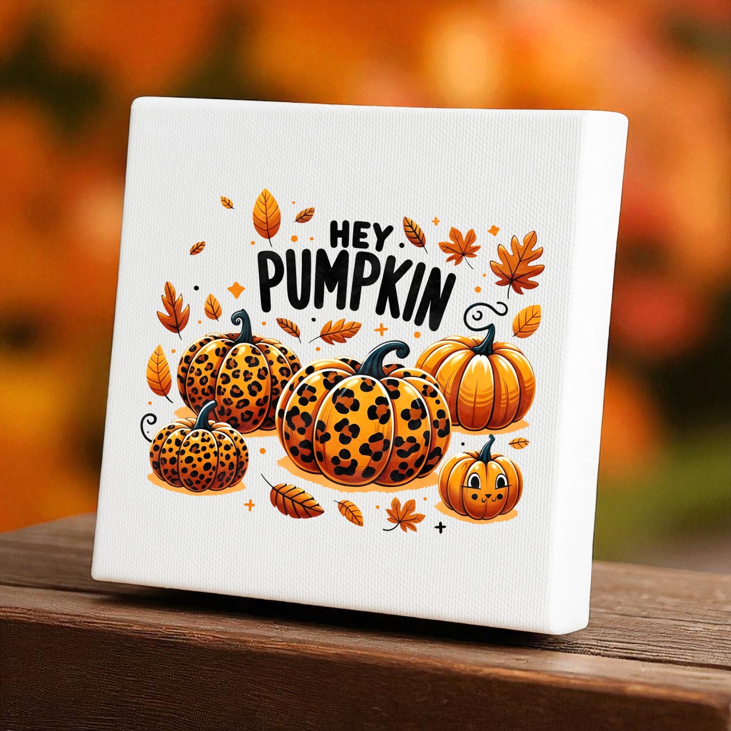 The Mirabilia Boutique Hey Pumpkin Canvas Sign (8x8) showcases leopard print pumpkins with autumn leaves and "HEY PUMPKIN" above, all in warm fall hues—perfect cozy decor for your home.