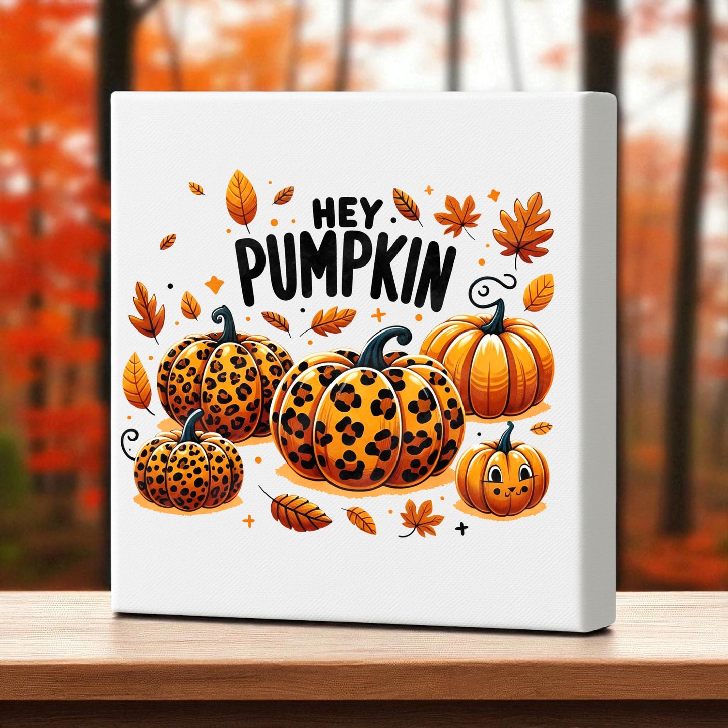 The Hey Pumpkin Canvas Sign by Mirabilia Boutique features leopard print pumpkins, autumn leaves, and "Hey Pumpkin" text on a blurred orange fall background—an 8x8 décor accent perfect for cozy autumn vibes.