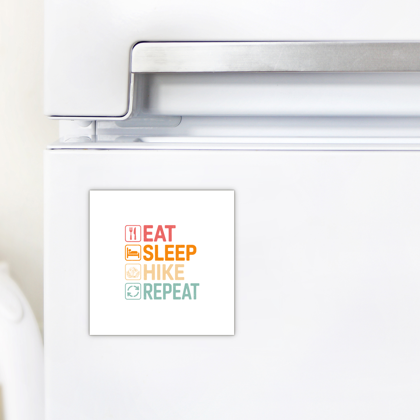 A white fridge with the Mirabilia Boutique "Eat Sleep Hike Repeat Magnet"—each word has a colorful icon. Perfect hiking gift or decor for outdoor lovers.