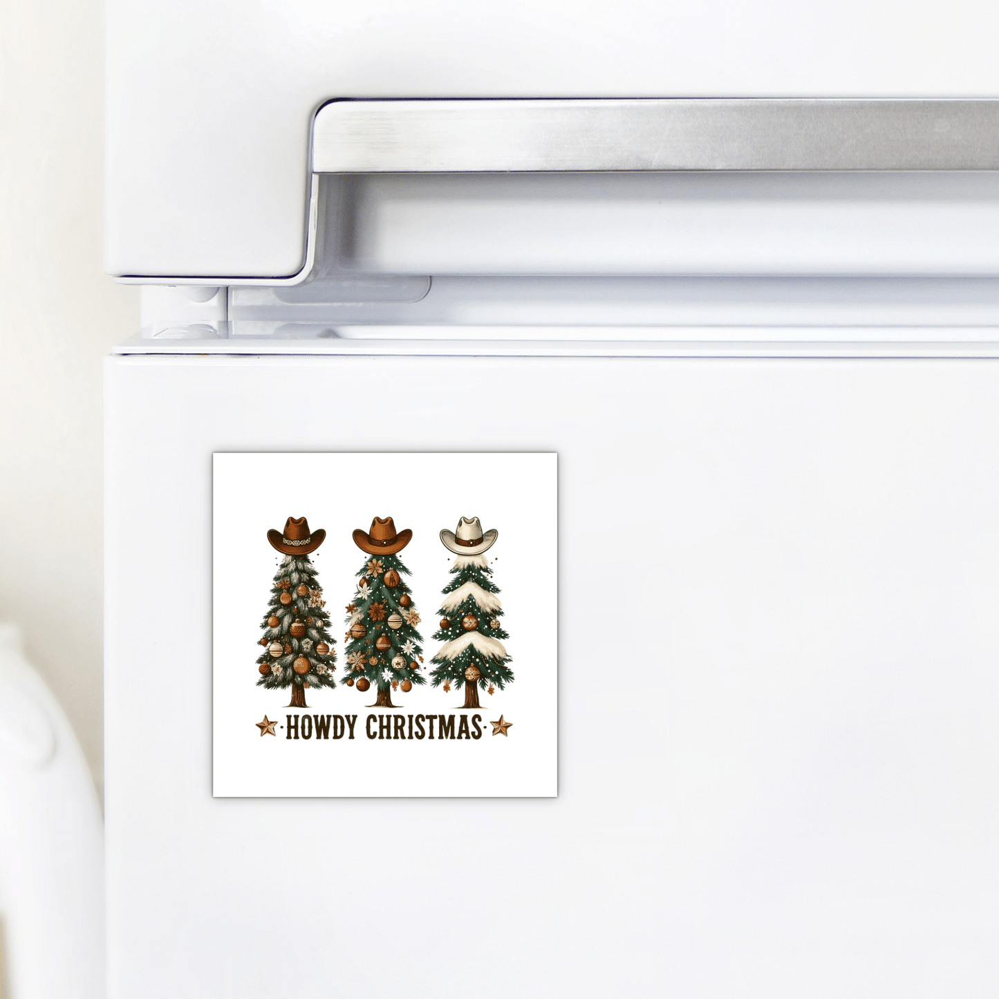 The Howdy Christmas Magnet by Mirabilia Boutique features three cowboy hat-topped trees and “Howdy Christmas” in rustic letters—perfect Western holiday decor for your fridge.