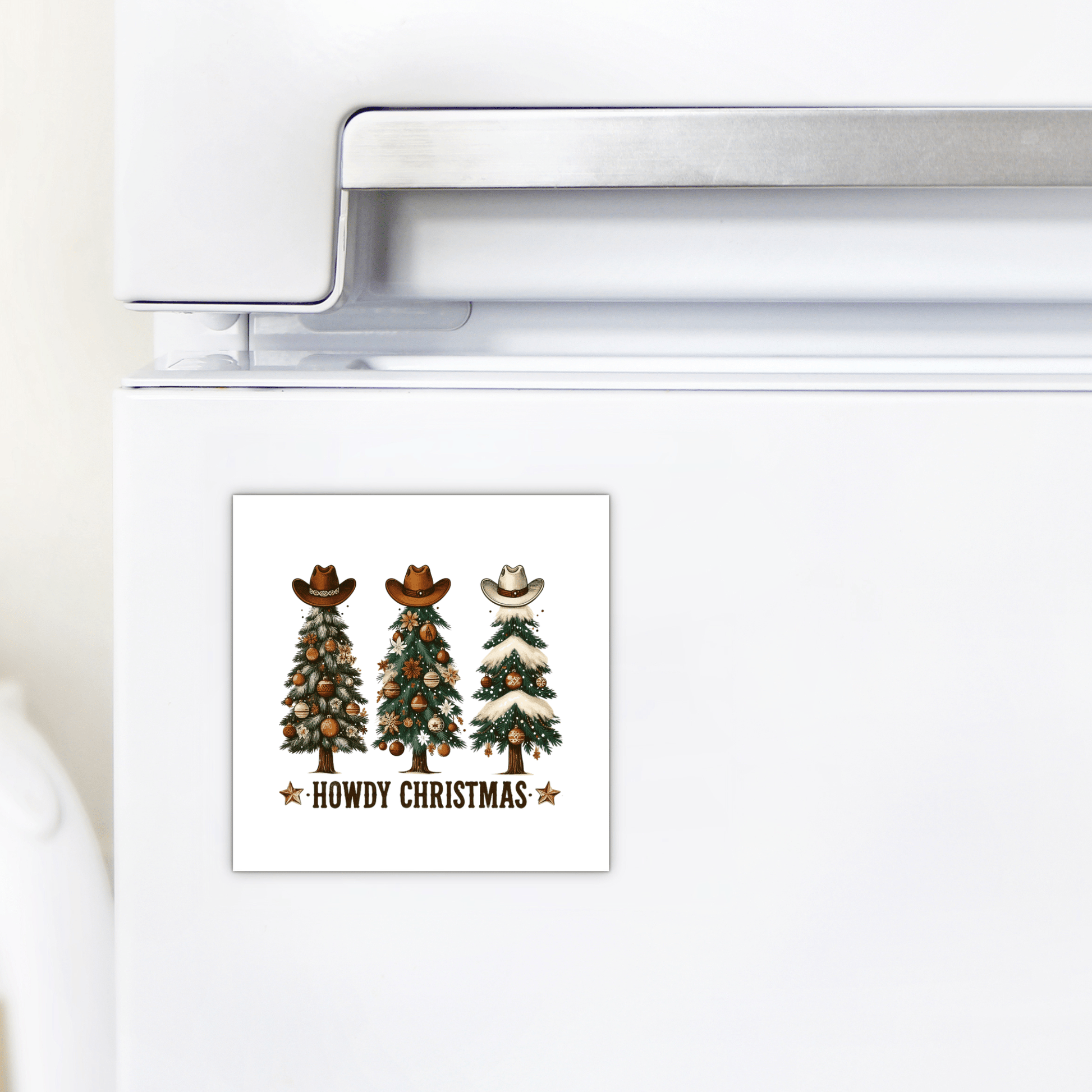The Howdy Christmas Magnet by Mirabilia Boutique features three cowboy hat-topped trees and “Howdy Christmas” in rustic letters—perfect Western holiday decor for your fridge.
