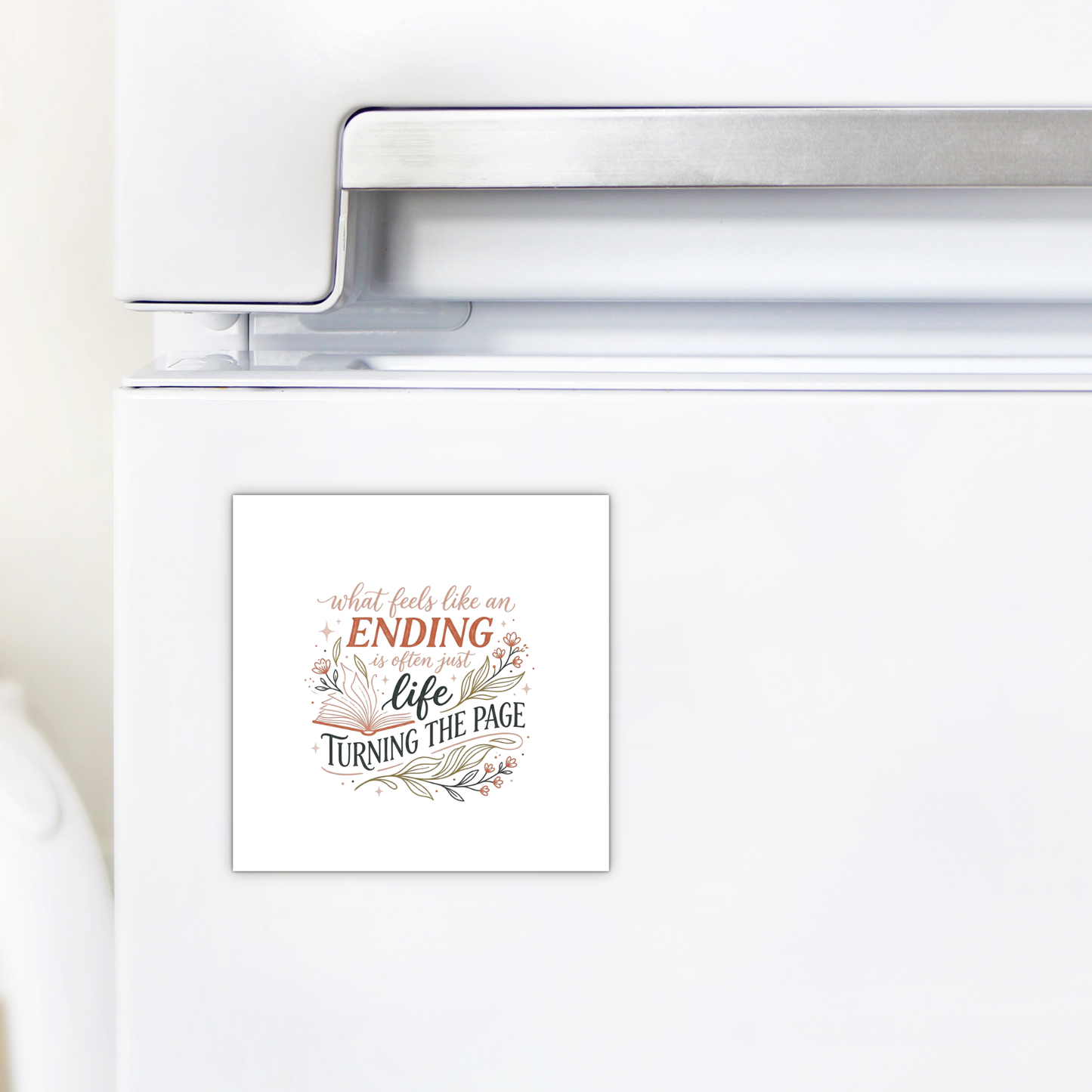 The Mirabilia Boutique Life Turning the Page Inspirational Magnet, featuring the quote "What feels like an ending is often just life turning the page," decorates a white refrigerator—a thoughtful literary gift for book lovers.