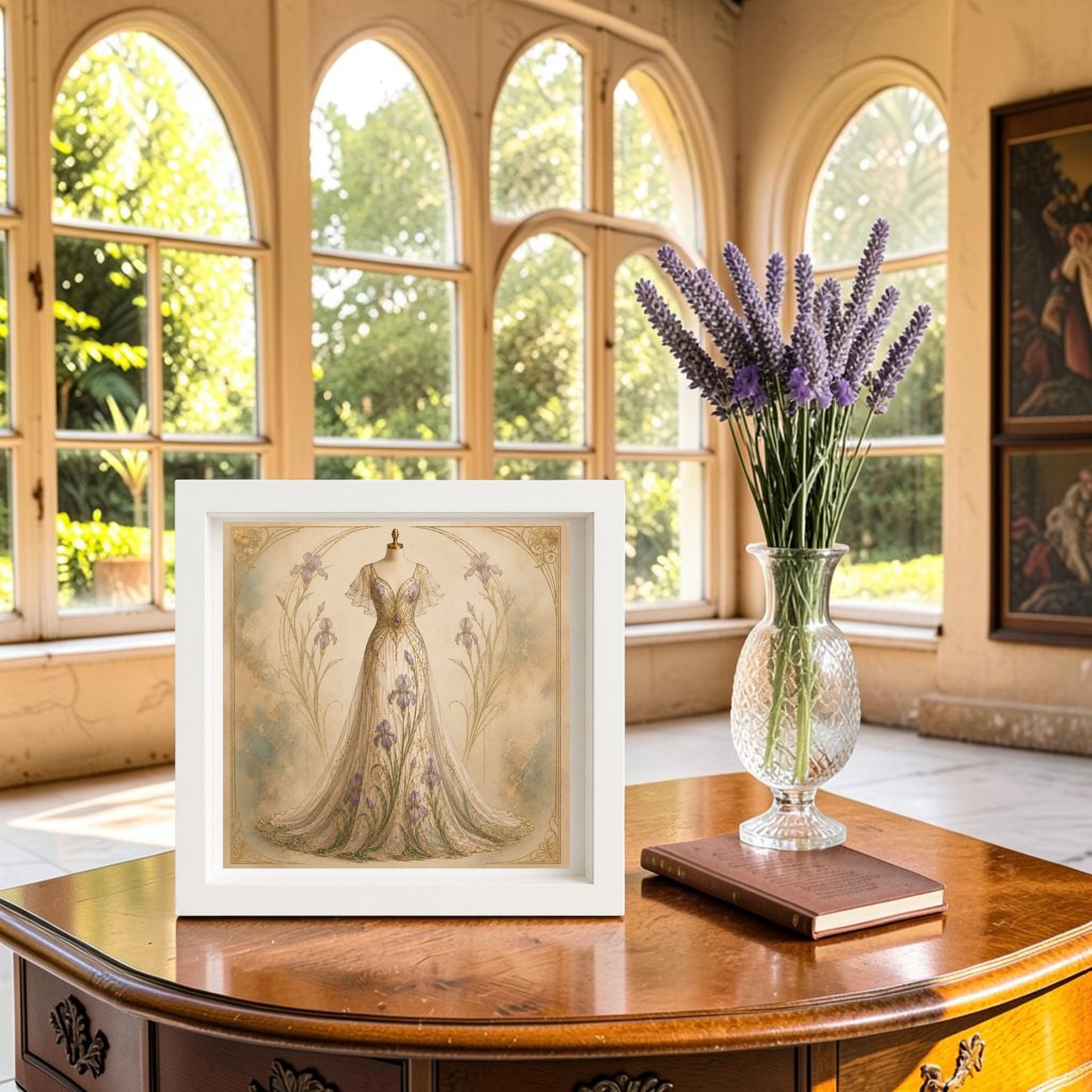 The Iris Elegance | Curated Couture Artwork by Mirabilia Boutique, a framed illustration of a floral dress, is displayed on a polished wooden table beside a vase of lavender in a sunlit room with large arched windows overlooking the garden, evoking the elegant curves and organic motifs characteristic of Art Nouveau style.