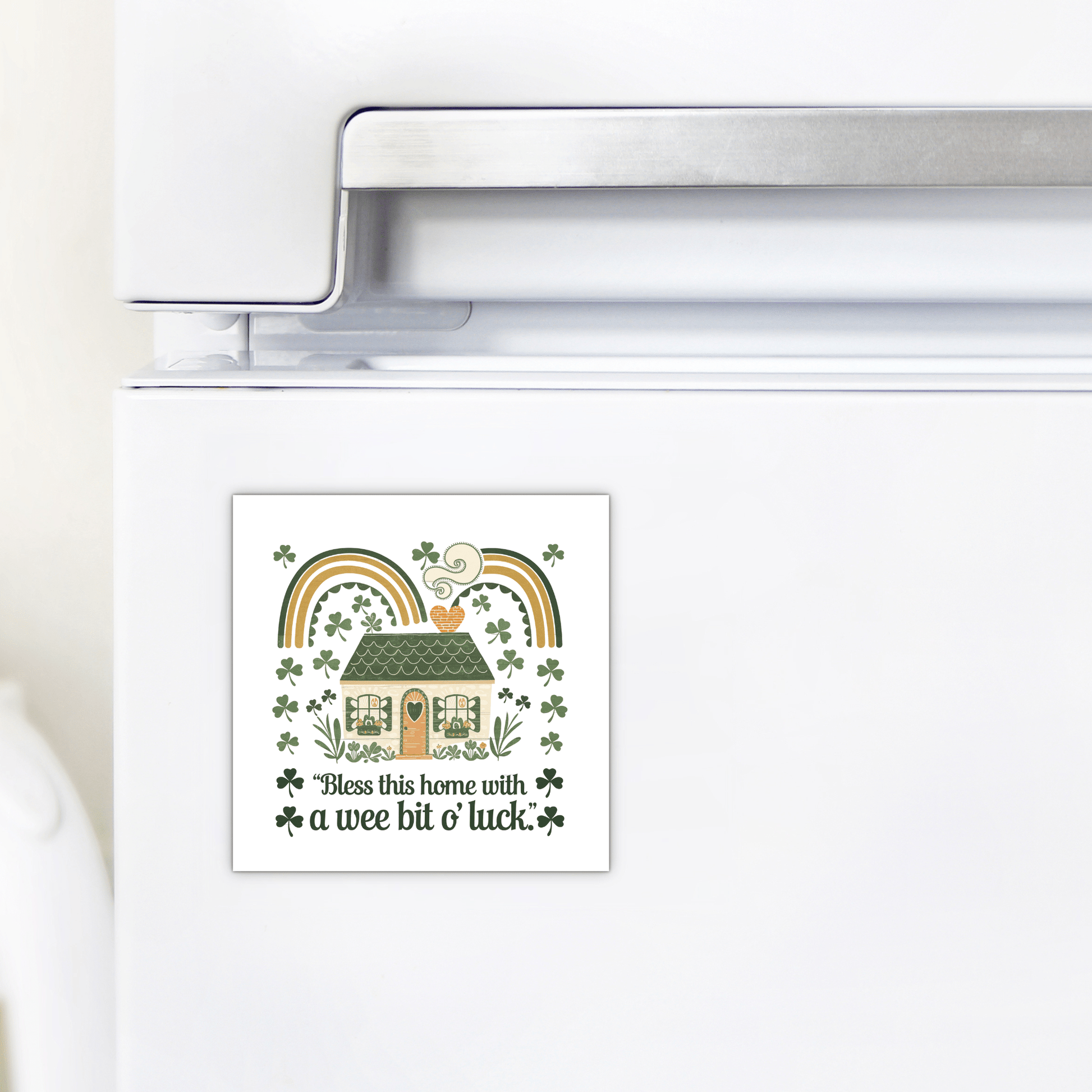 The Wee Bit o’ Luck Irish Home Magnet by Mirabilia Boutique adds festive Celtic charm to your fridge, featuring a house, rainbows, shamrocks, and "Bless this home with a wee bit o' luck" in green and gold. Perfect for St. Patrick's Day decor!.