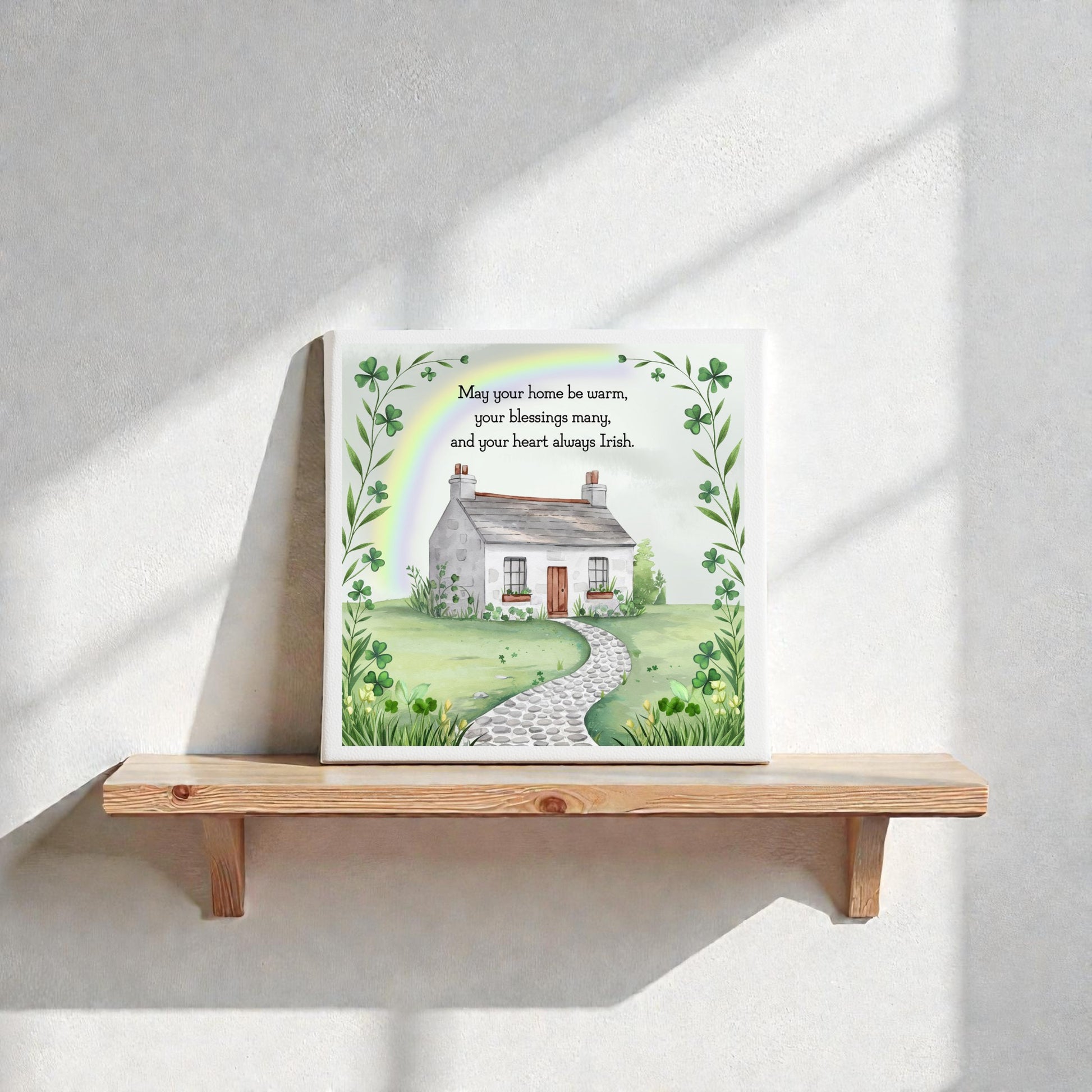 The Mirabilia Boutique Irish Heart Home Blessing Canvas – 8x8 Quote Sign features a cottage and garden with green clover leaves, making it a charming housewarming decor or thoughtful gift for celebrating Irish heritage.