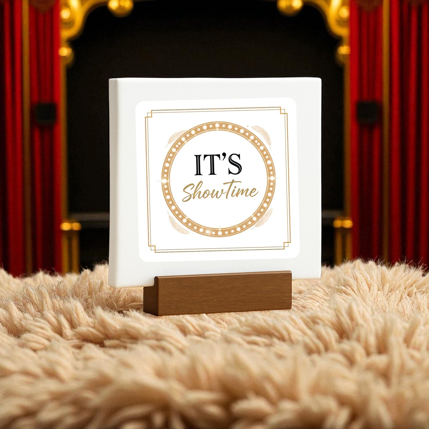 The It’s Showtime Mini Sign by Mirabilia Boutique features gold and black text on white, displayed on a wooden holder atop a beige surface—ideal Broadway-inspired decor from the Gold Glam Stage Decor collection.