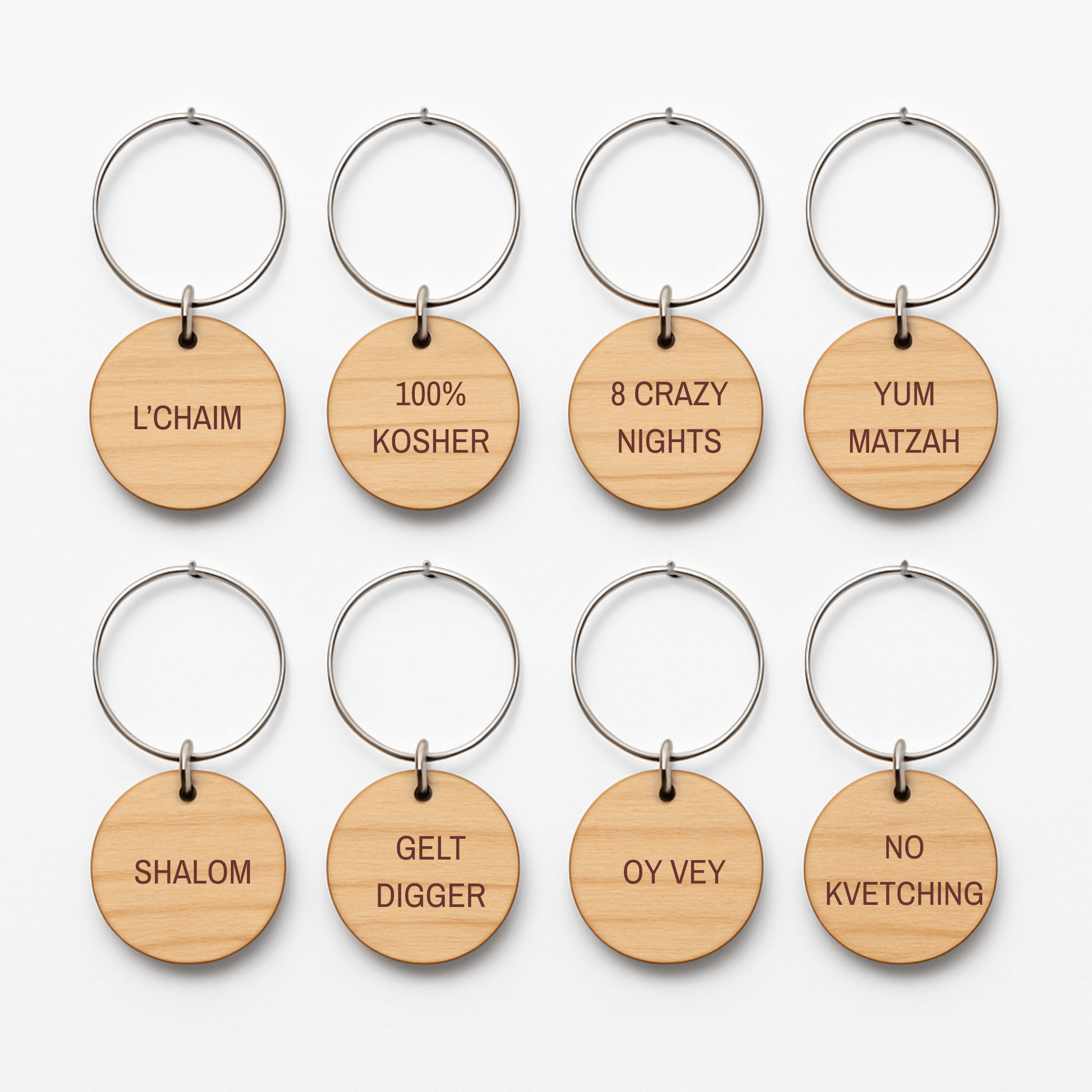 Mirabilia Boutique’s Jewish Wine Charms—Hanukkah Wine Glass Markers Set of 8—feature engraved wooden tags with festive Jewish phrases like “L’CHAIM” and “100% KOSHER,” ideal as holiday gifts or Hanukkah wine charms.