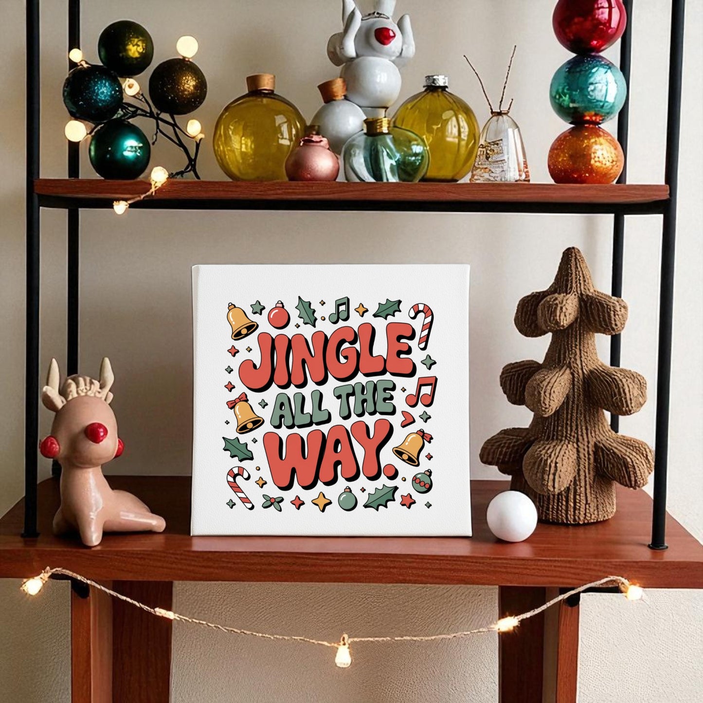 Create a festive shelf with colorful ornaments, a reindeer figurine, string lights, and the Mirabilia Boutique “Jingle All the Way Canvas”—an 8x8 Christmas wall art gift that complements your holiday decor.