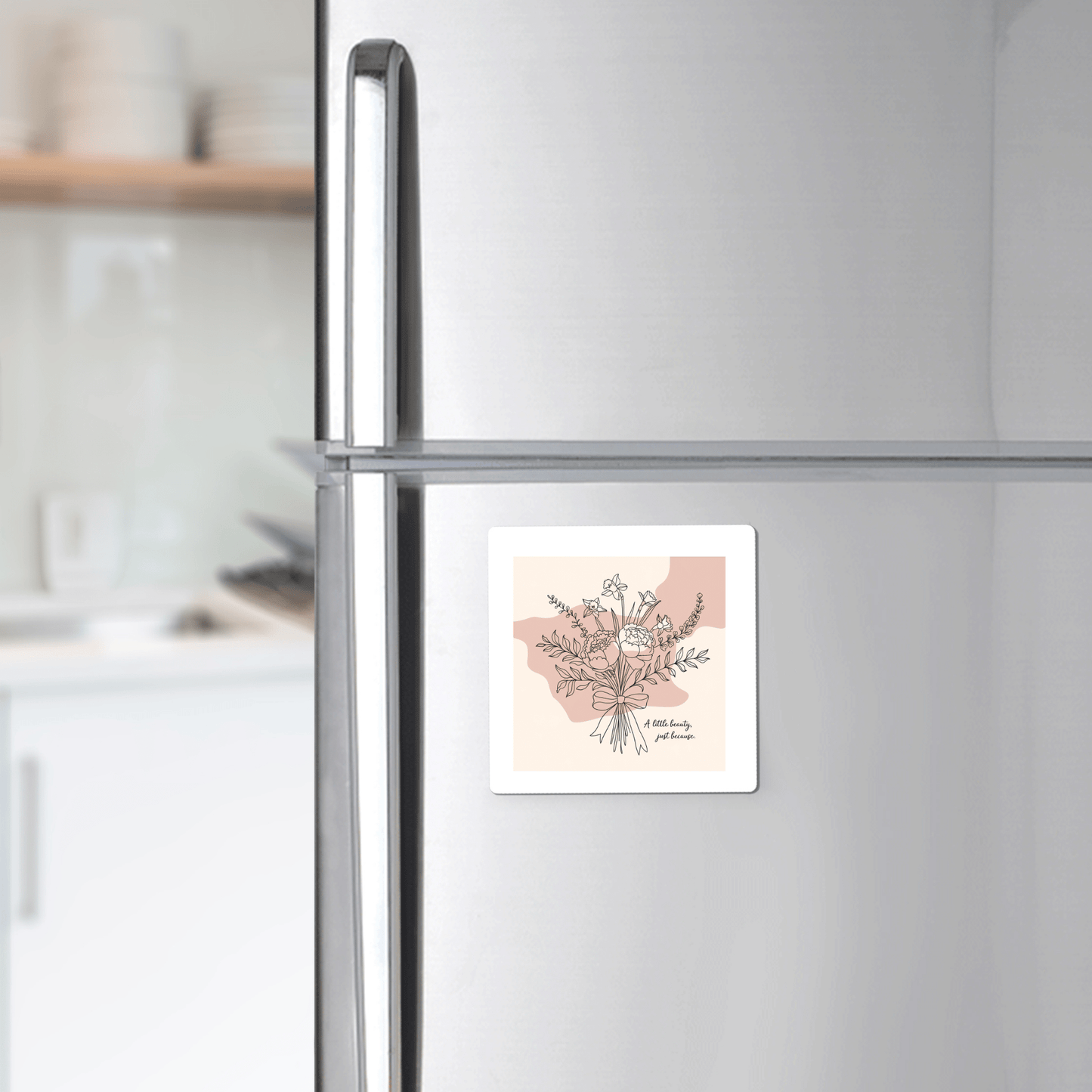 The A Little Beauty Magnet – Just Because Floral Gift by Mirabilia Boutique is shown on a silver fridge in a modern kitchen, making it a charming and thoughtful thinking of you gift.