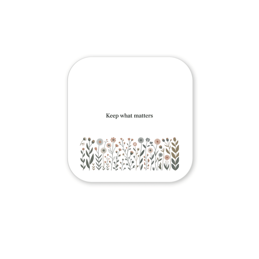 The Keep What Matters Floral Magnet by Mirabilia Boutique features "Keep what matters" above pastel flowers and leaves on a white square with rounded corners—a charming accent for cottage décor.