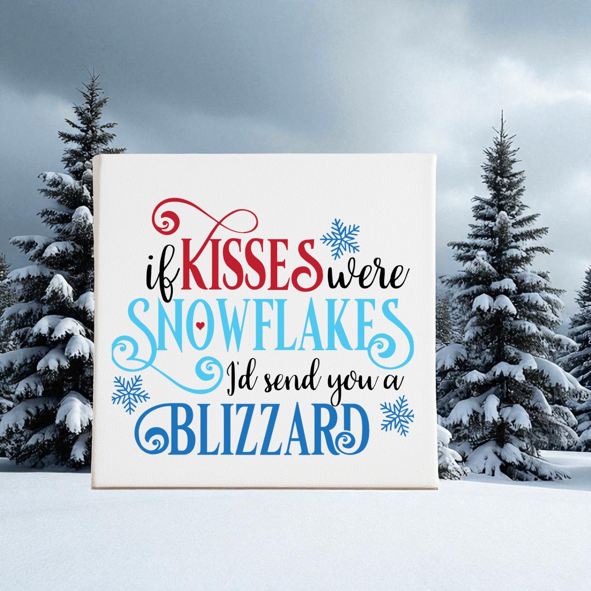 The "If Kisses Were Snowflakes" Winter Quote Wall Art by Mirabilia Boutique features a romantic blizzard sign with festive script, snowflake illustrations, and pine trees—perfect decor for a seasonal touch.