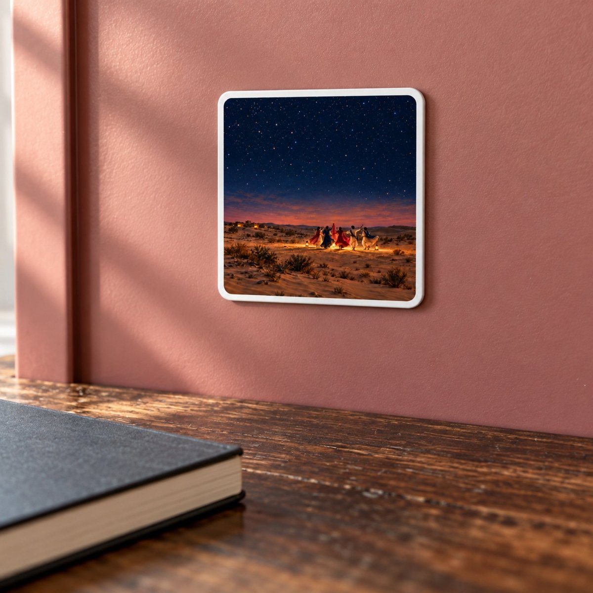 The Night We Danced Magnet is a square decorative hardboard magnet depicting figures in colorful robes dancing in a desert at night under a starry sky in the style of Rajasthan artwork.