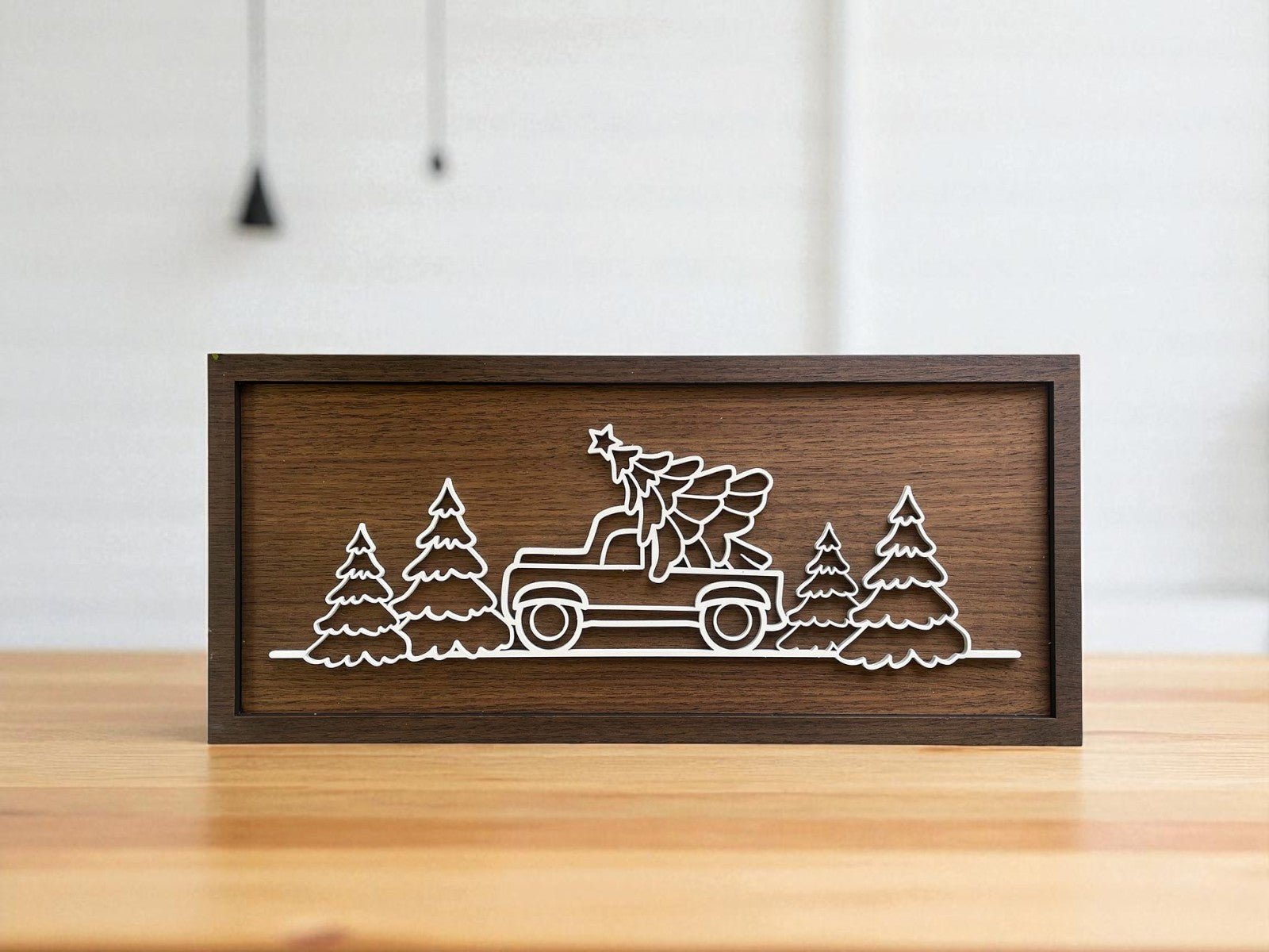 The Truck & Tree Laser Cut Christmas Sign (9x4) by Mirabilia Boutique features a white vintage truck with a tree and pines, making it a perfect rustic accent for modern farmhouse decor.