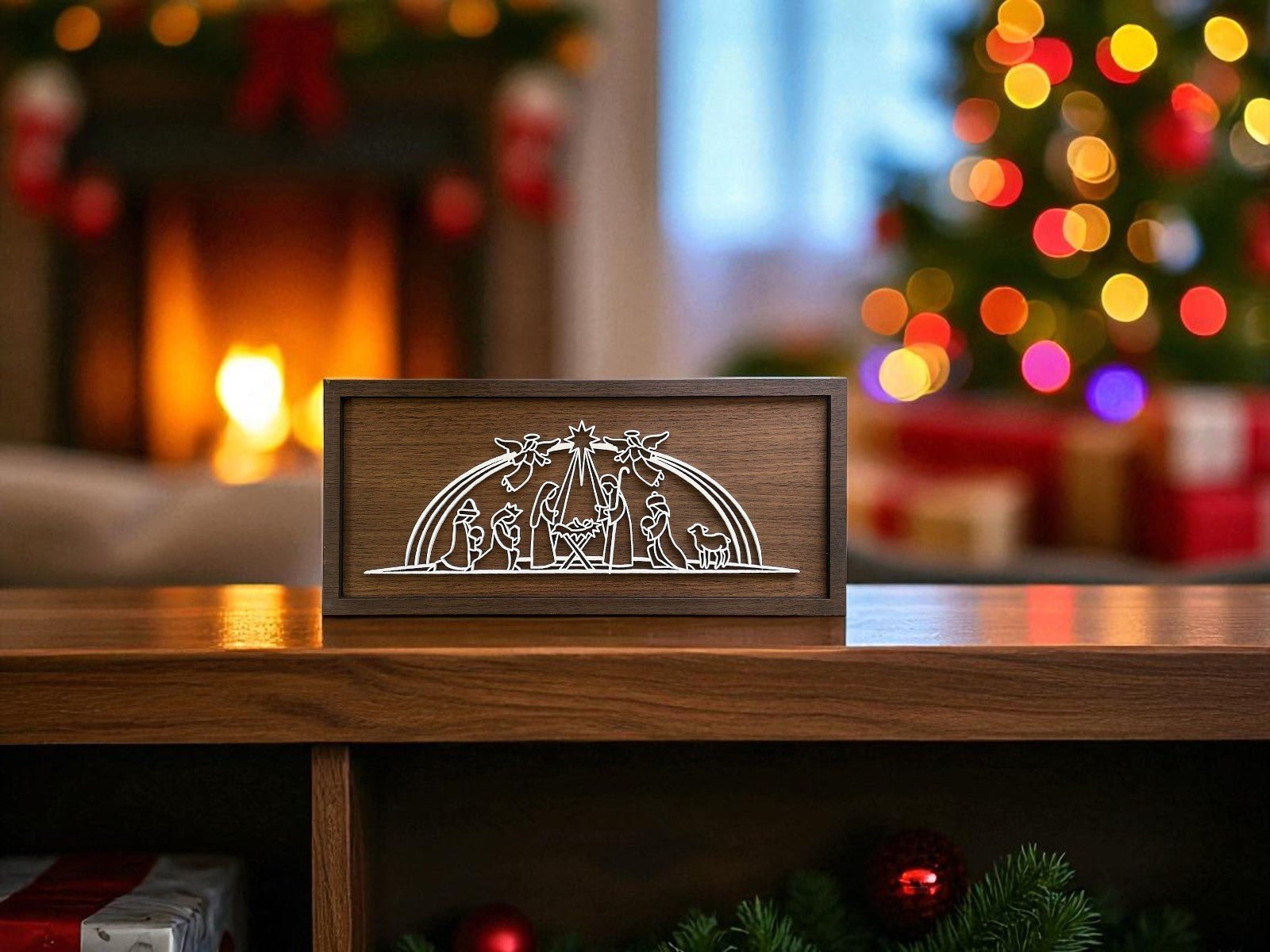 The Mirabilia Boutique Laser Cut Nativity Sign, a handmade 9x4 wooden decor piece, sits on a table amid festive Christmas touches—twinkling tree lights, gifts, and a glowing fireplace set a warm holiday scene.