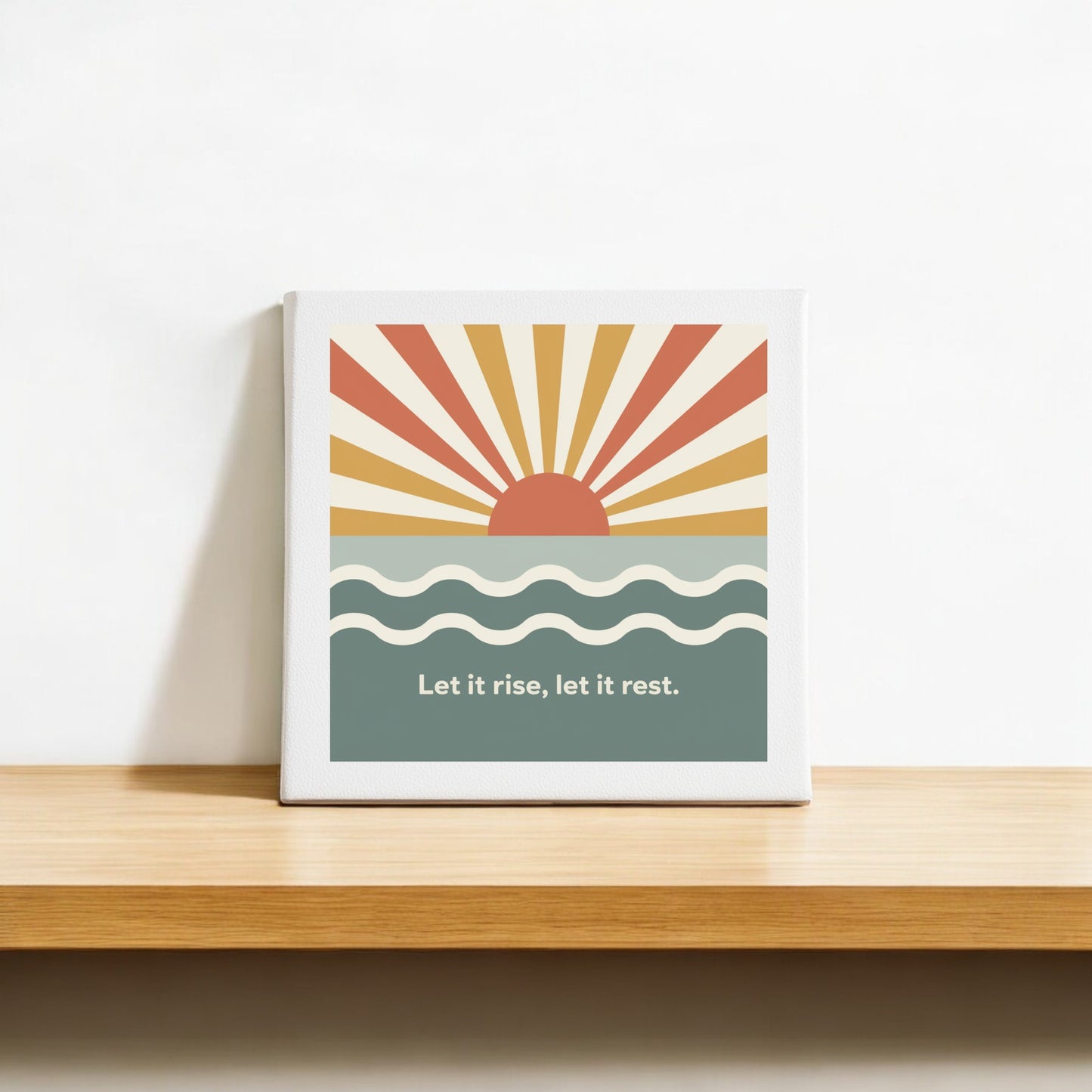 The Let It Rise, Let It Rest Canvas – Sunrise Mindful Art by Mirabilia Boutique features a stylized sun above sea-like waves with the phrase "Let it rise, let it rest" on a white background—perfect sunrise decor for your shelf.