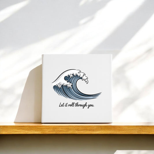 The Let It Roll Through You Canvas – Ocean-Inspired Calm by Mirabilia Boutique features a stylized blue wave and uplifting text, making it soothing meditation decor, ideal for displaying on a shelf with gentle sunlight and shadows.