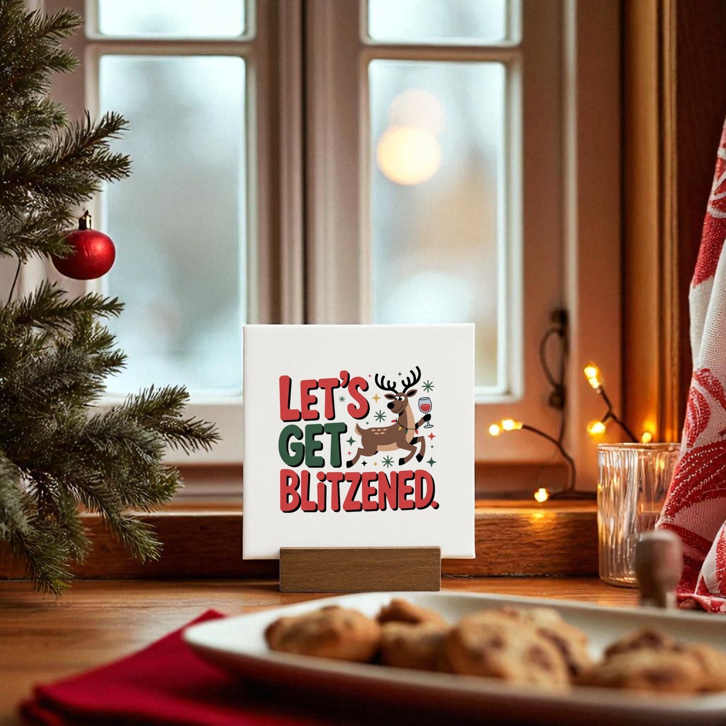 The Let’s Get Blitzened Mini Christmas Sign by Mirabilia Boutique is a funny holiday decor piece with a cartoon reindeer, ideal for festive windowsills or as a fun wine-themed gift.