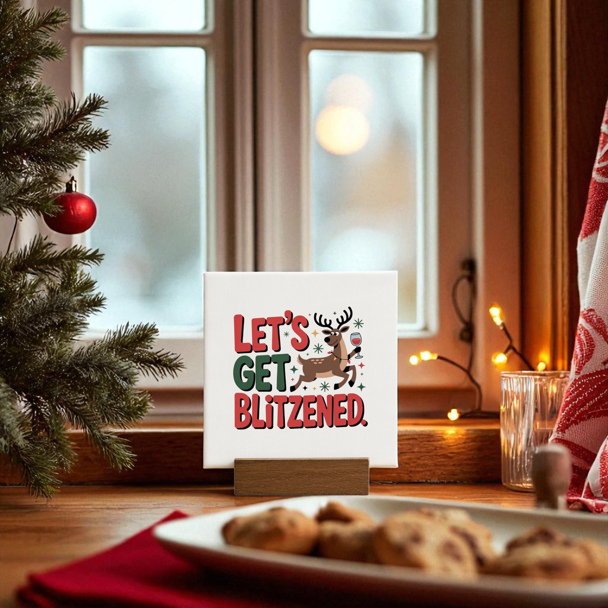The Let’s Get Blitzened Mini Christmas Sign by Mirabilia Boutique is a funny holiday decor piece with a cartoon reindeer, ideal for festive windowsills or as a fun wine-themed gift.