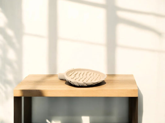 The Light Brown Pinecone Tray by Mirabilia Boutique rests on a light wooden table, bringing a charming, nature-inspired accent to the space—perfect for spring and fall decor.