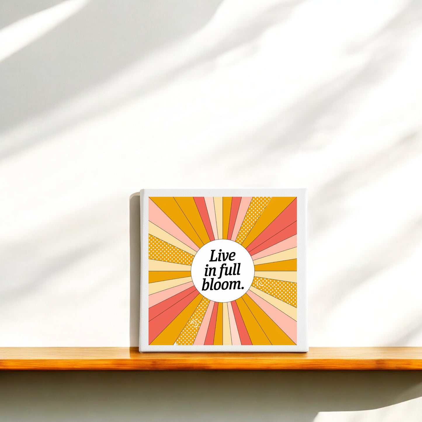 The Mirabilia Boutique "Live in Full Bloom Canvas – Vibrant Summer Sunburst Art" features colorful pink, yellow, and orange rays with polka dots and the uplifting phrase, adding a lively modern touch to any space.