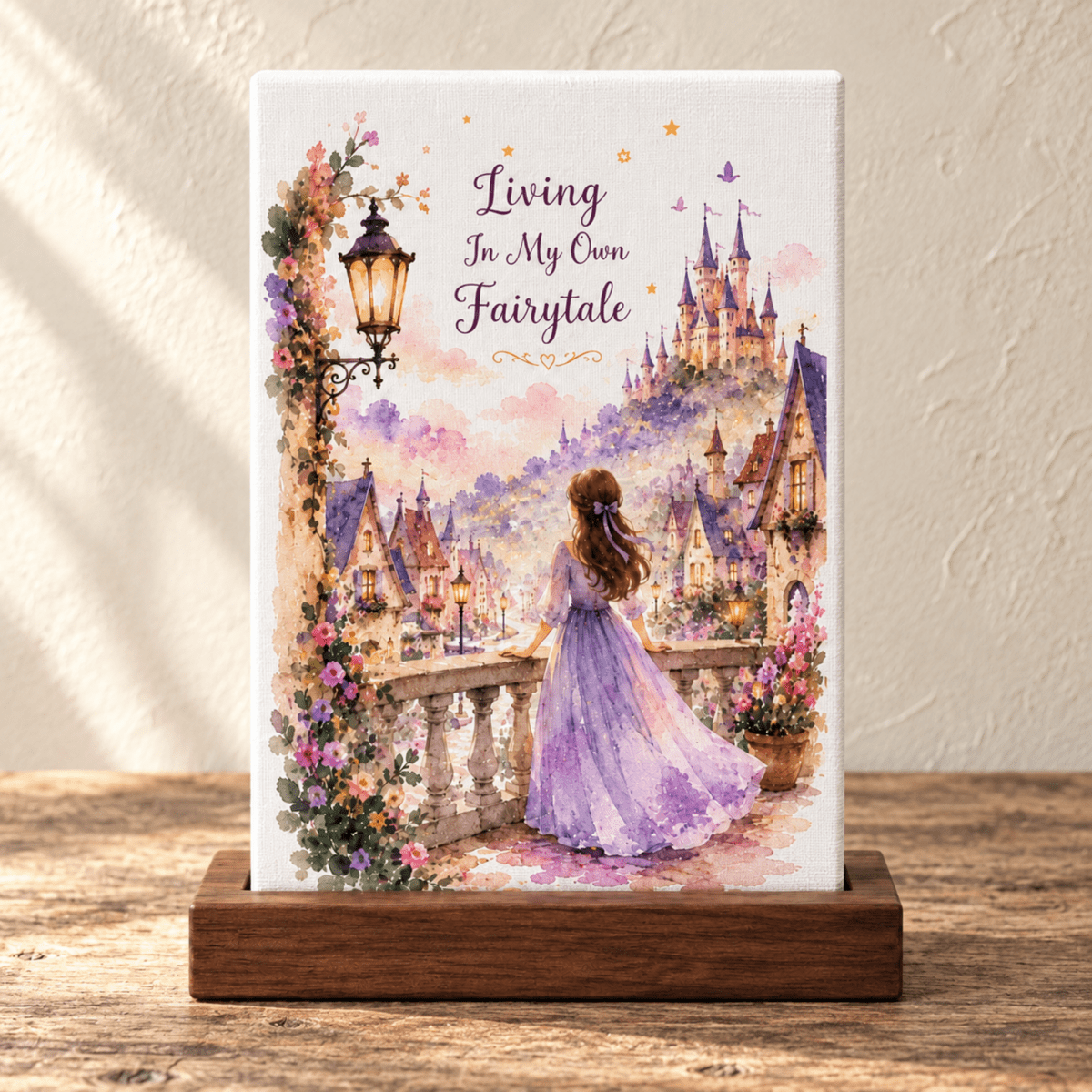 A Living in My Own Fairytale Mini Canvas on a wooden stand, featuring a person in a purple dress looking out at a castle with the text “Living In My Own Fairytale” above, ideal for cottagecore décor.
