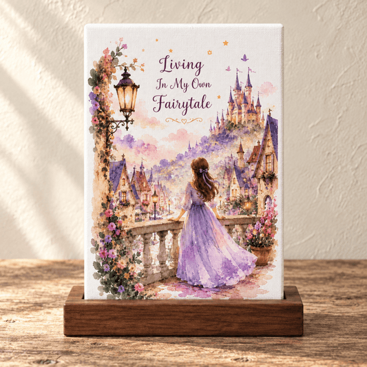 A Living in My Own Fairytale Mini Canvas on a wooden stand, featuring a person in a purple dress looking out at a castle with the text “Living In My Own Fairytale” above, ideal for cottagecore décor.