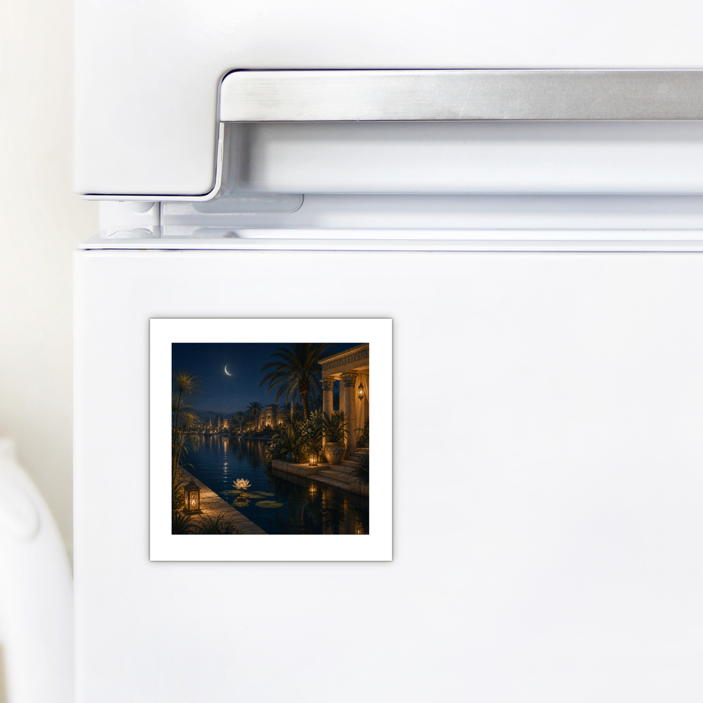 A “Lotus After Dark Magnet” by Mirabilia Boutique, depicting ancient Egyptian art, is attached to a white refrigerator door beneath the freezer handle.