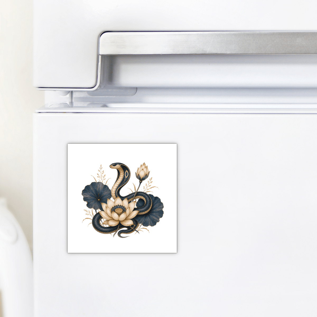 Enhance your kitchen with the Lotus Guardian Cobra Magnet | Egyptian Lotus Art by Mirabilia Boutique—a square magnet designed for your white refrigerator. Showcasing a striking illustration of a cobra coiled around a pale lotus flower with dark blue-green leaves and beige accents, this piece from the Lapis & Lotus collection adds an elegant touch of Egyptian décor and mystique to any space.