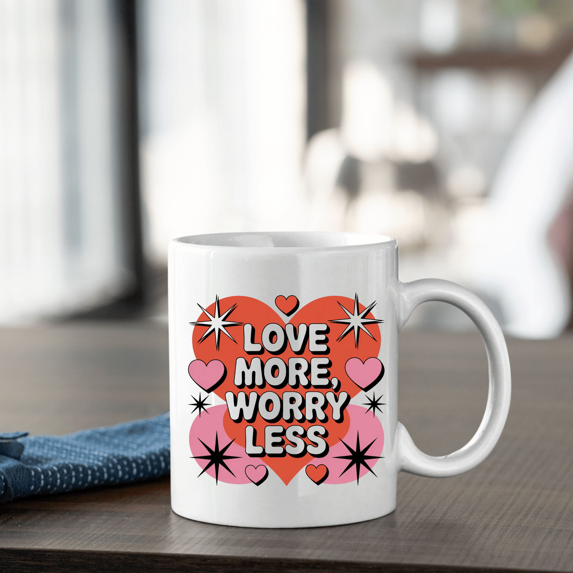 The Love More Worry Less Mug by Mirabilia Boutique features a retro red heart with “Love More, Worry Less,” pink hearts, and black stars—an ideal Valentine’s Day gift from the Retro Valentine Coffee Cup collection.
