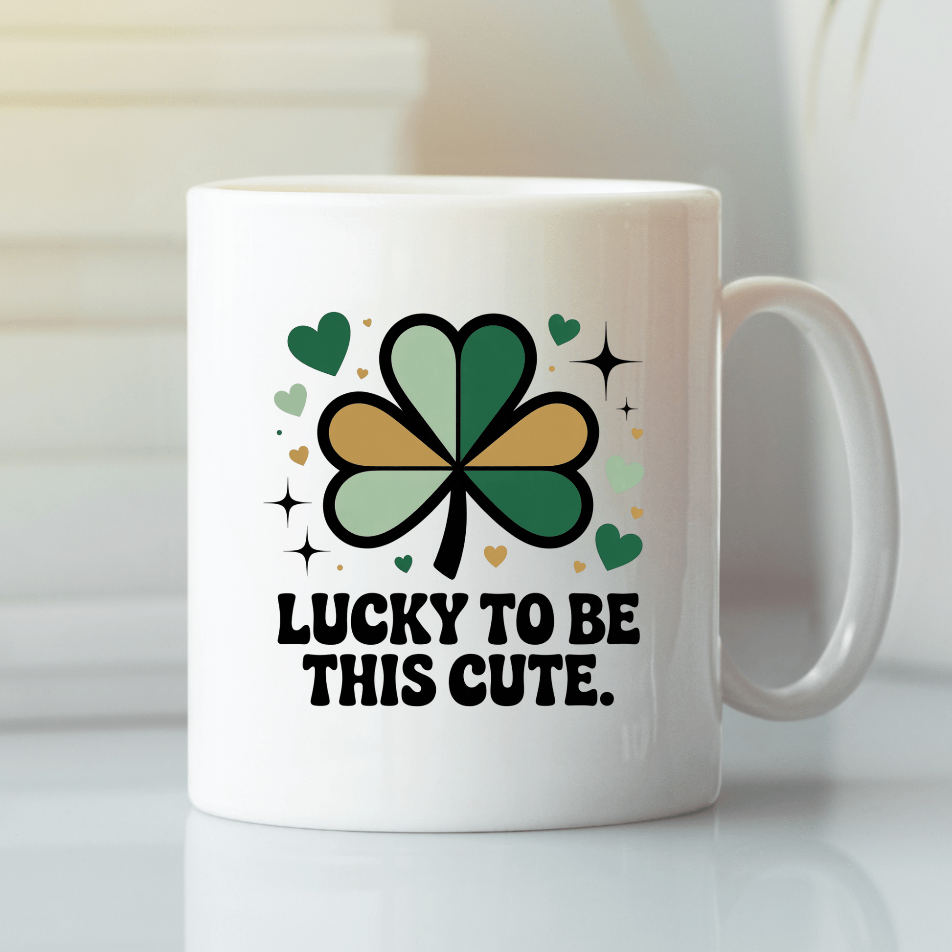 The Lucky to Be This Cute Shamrock Mug by Mirabilia Boutique is a white retro mug with a green and gold shamrock, hearts, sparkles, and bold black text—perfect for spreading cheer and self-love.