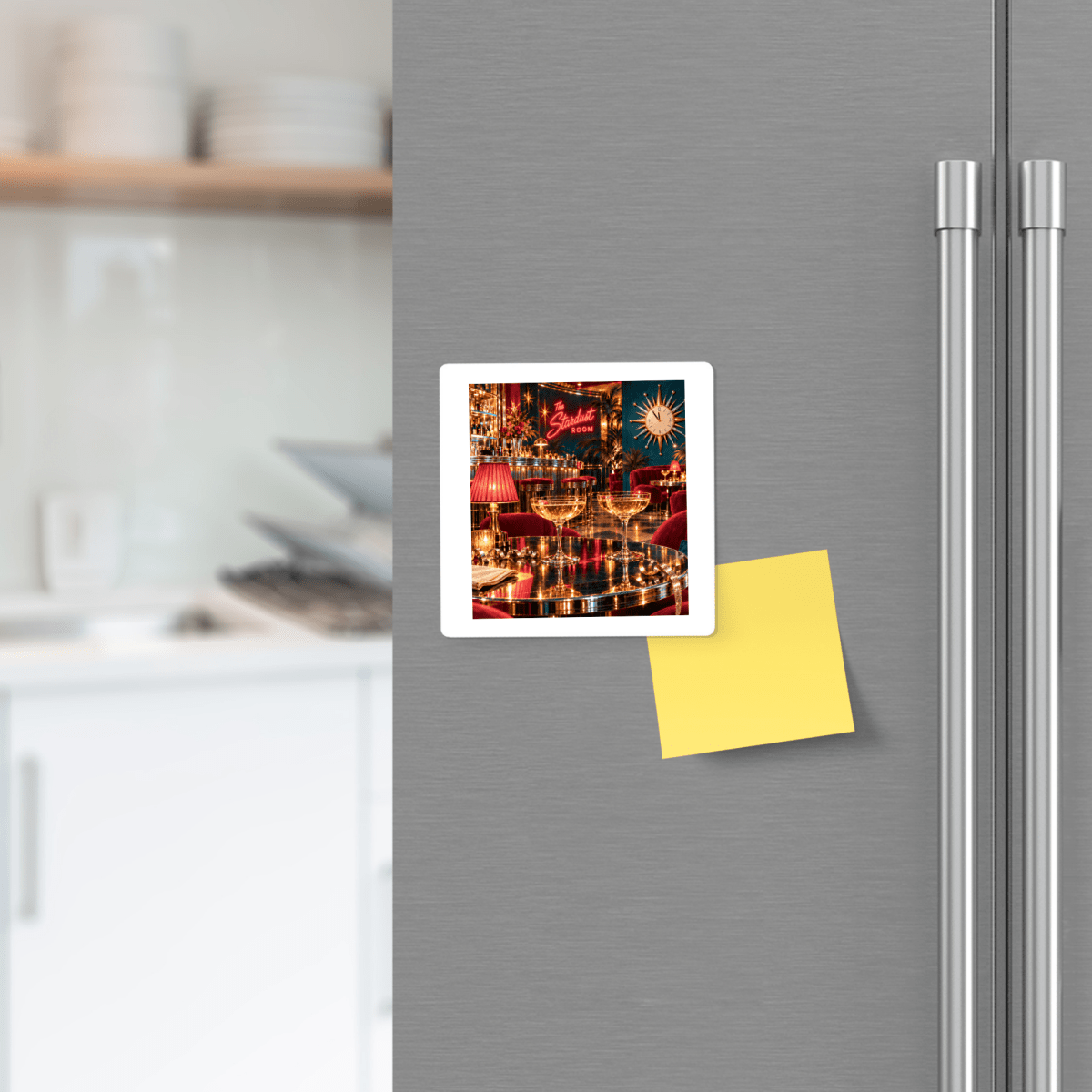 Square Five Minutes to Midnight Magnet | Chrome & Starlight on a stainless steel refrigerator featuring two champagne glasses on a bar table inside a dimly lit, mid-century decor lounge.