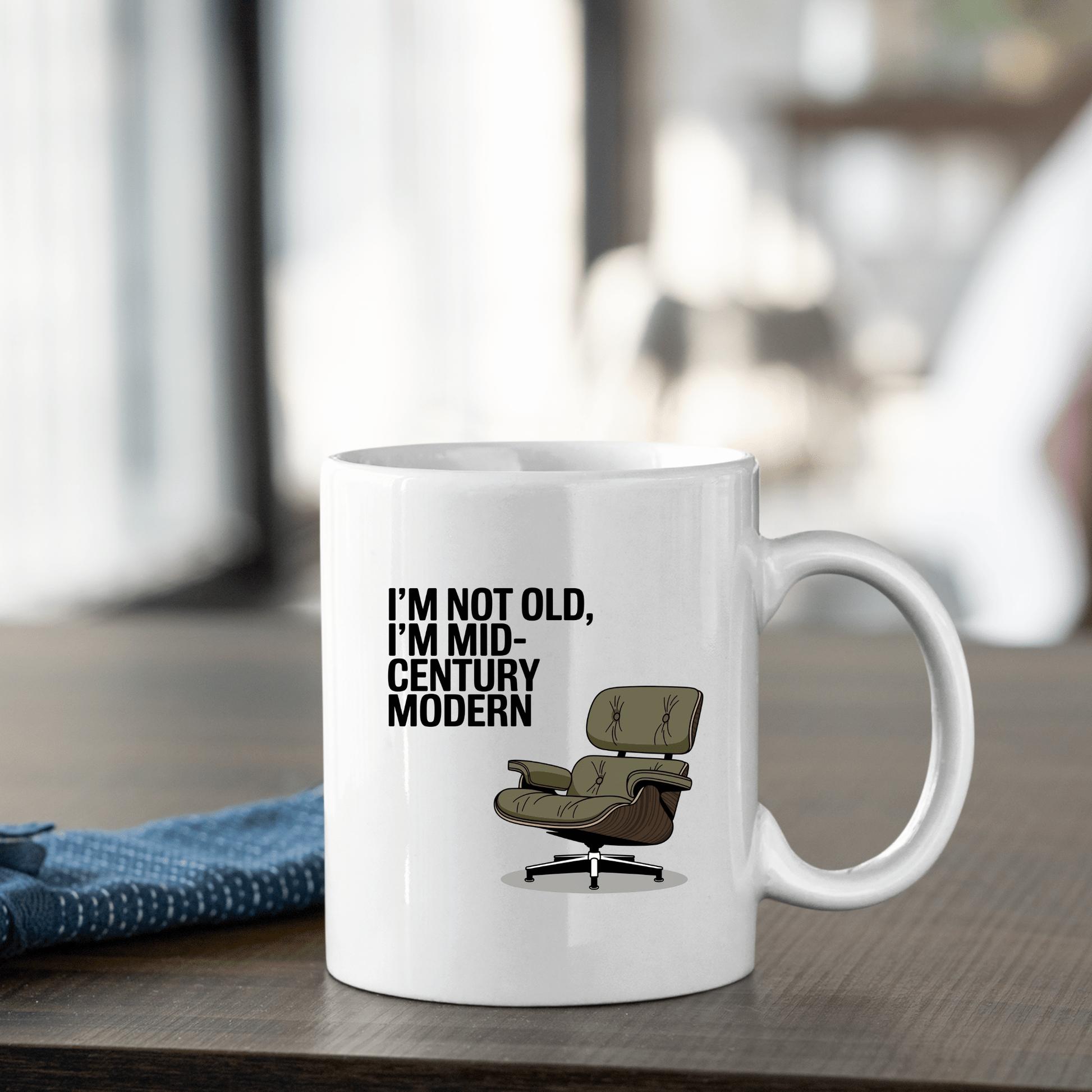 The Mirabilia Boutique Mid-Century Modern Mug with Retro Humor features “I'M NOT OLD, I'M MID-CENTURY MODERN” and a lounge chair illustration—perfect for vintage design lovers.
