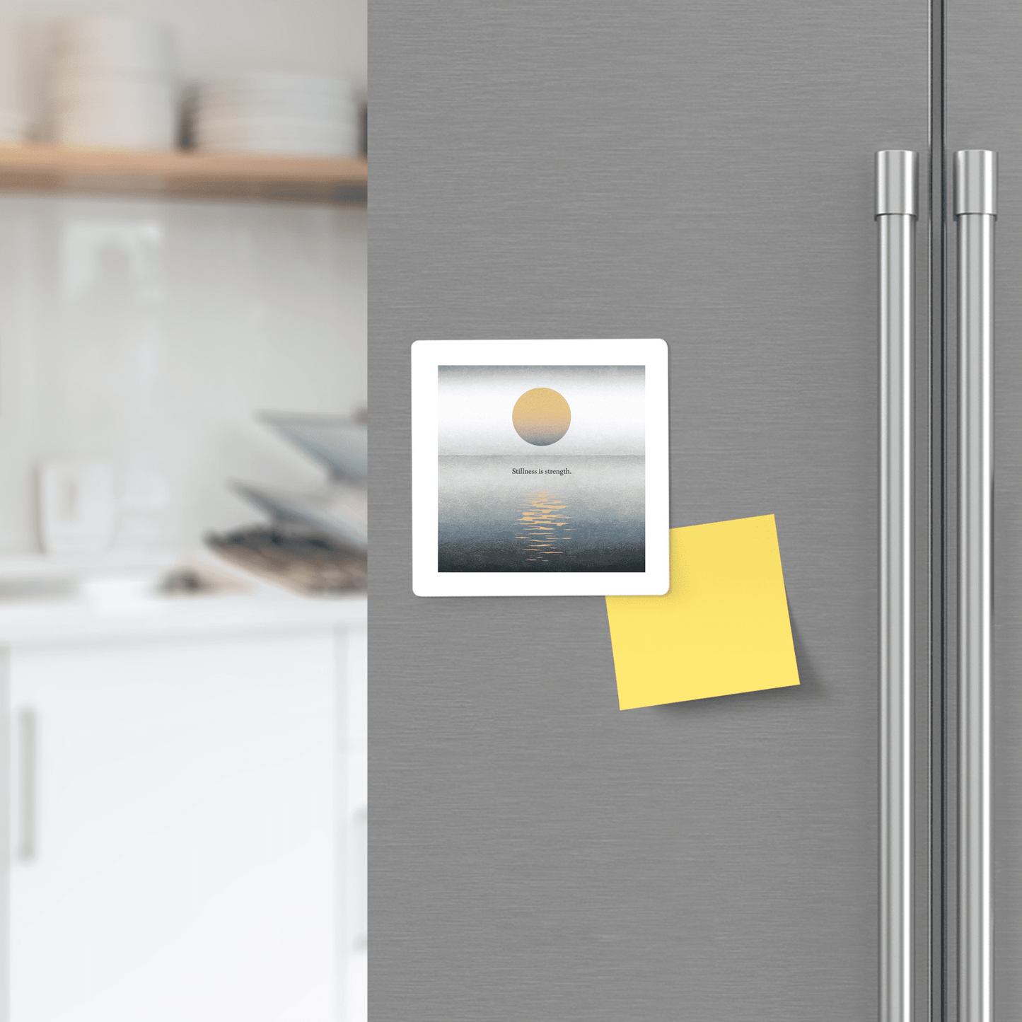 The Stillness Is Strength Magnet from Mirabilia Boutique, featuring a sun over water and "believe in strength," plus a yellow sticky note, brings mindful motivation and calm minimalist decor to any modern kitchen.