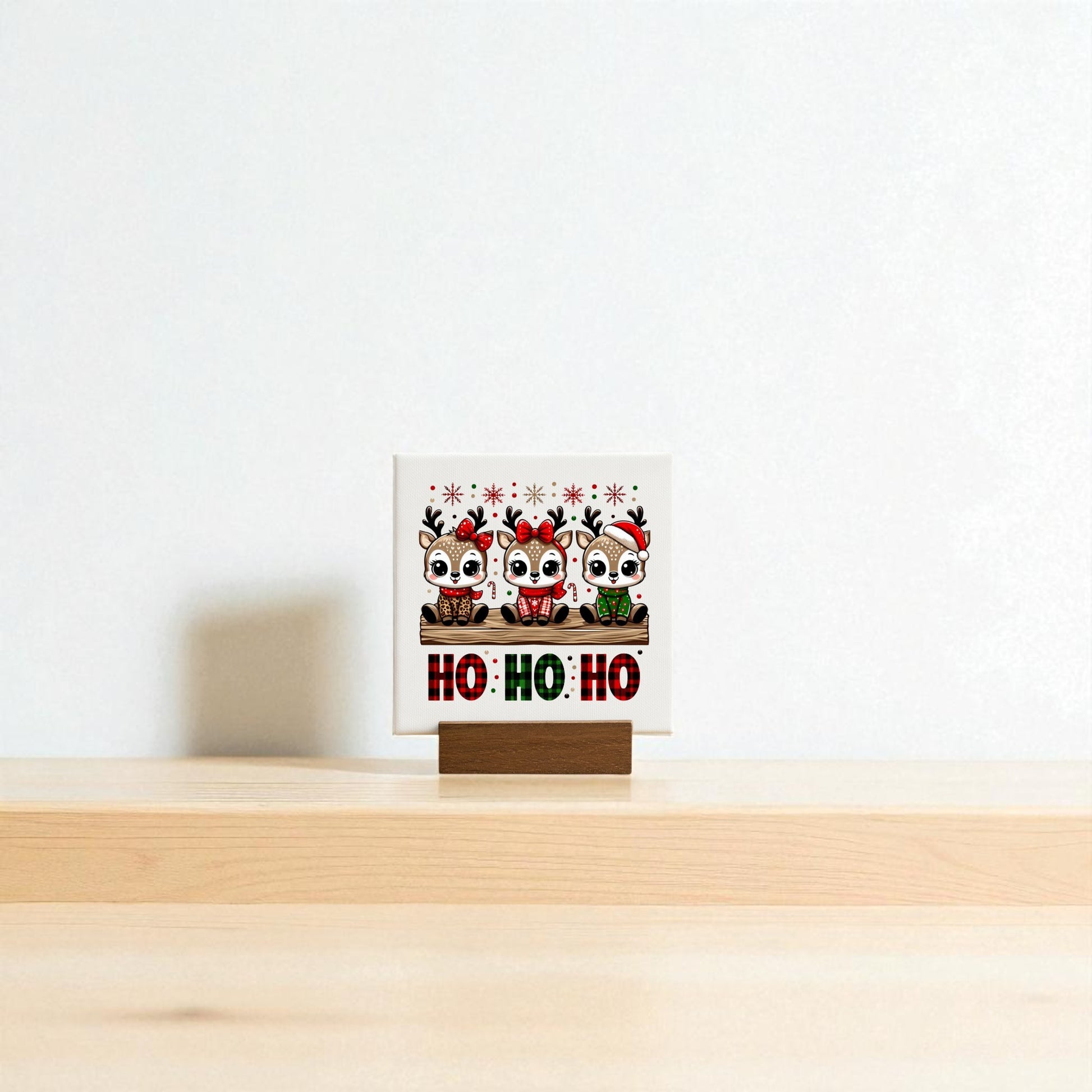 Mirabilia Boutique’s Ho Ho Ho Reindeer Mini Christmas Sign (4x4) features three cartoon reindeer in festive hats and scarves, with “HO! HO! HO!” — perfect for charming holiday shelf decor.