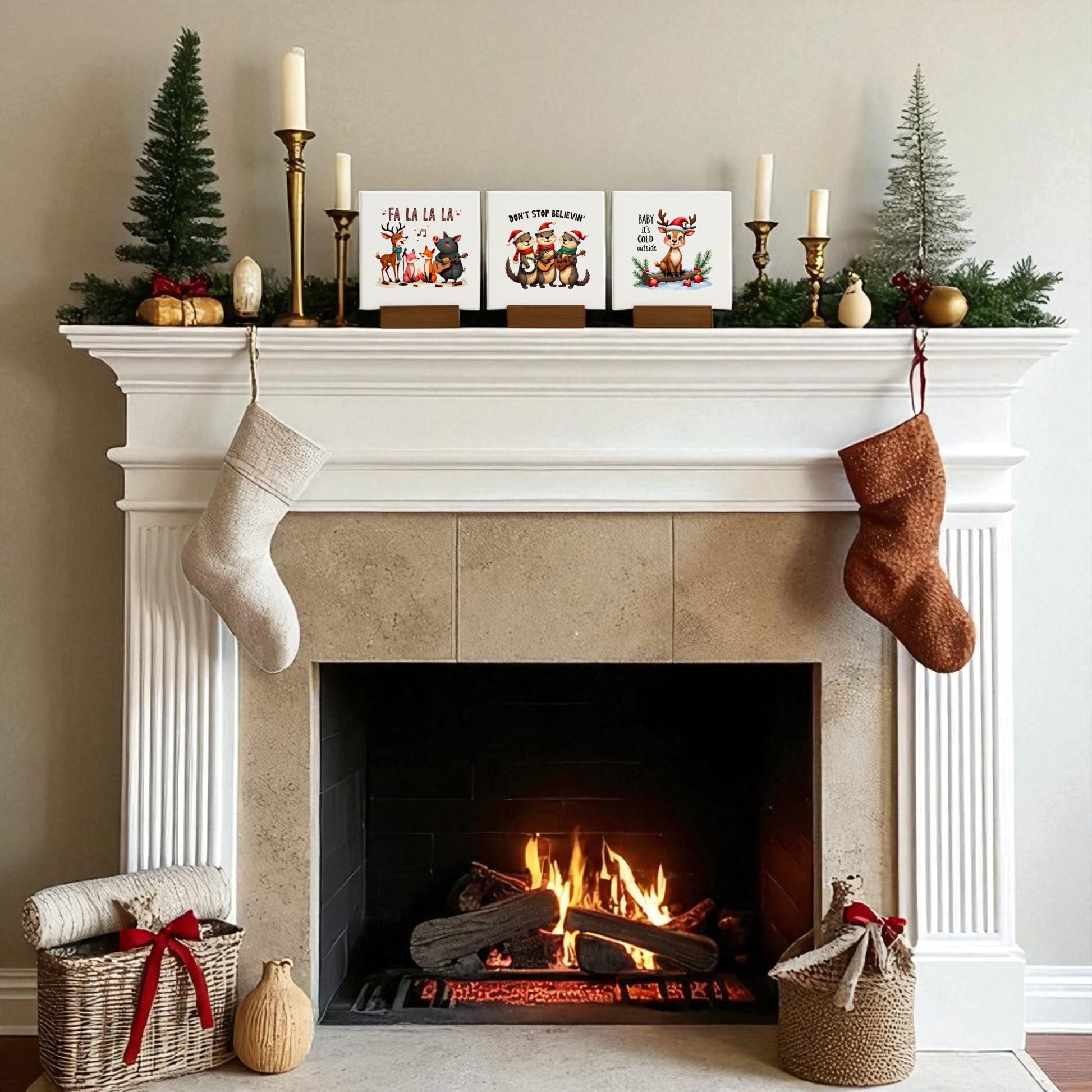 A cozy fireplace glows with a festive fire, its mantel adorned with stockings, Christmas mantel decor, mini trees, and the Mirabilia Boutique Fa La La, Don’t Stop Believin’, Baby It's Cold Mini Christmas Sign Trio. Baskets with bows rest beside the hearth.