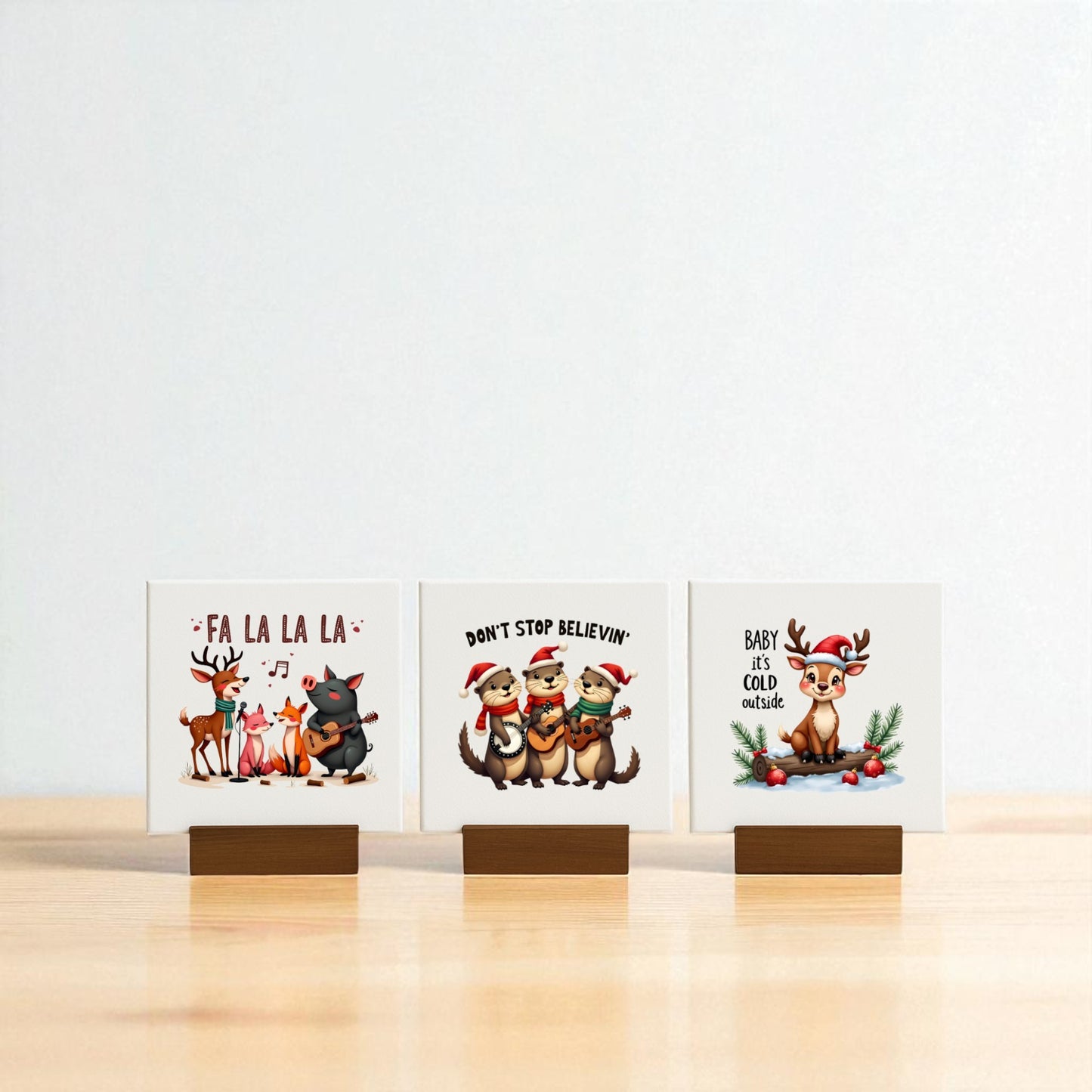 The Fa La La, Don’t Stop Believin, Baby It's Cold Mini Christmas Sign Trio by Mirabilia Boutique features three festive signs on wooden stands—perfect for holiday decor or as charming Christmas mantel accents.