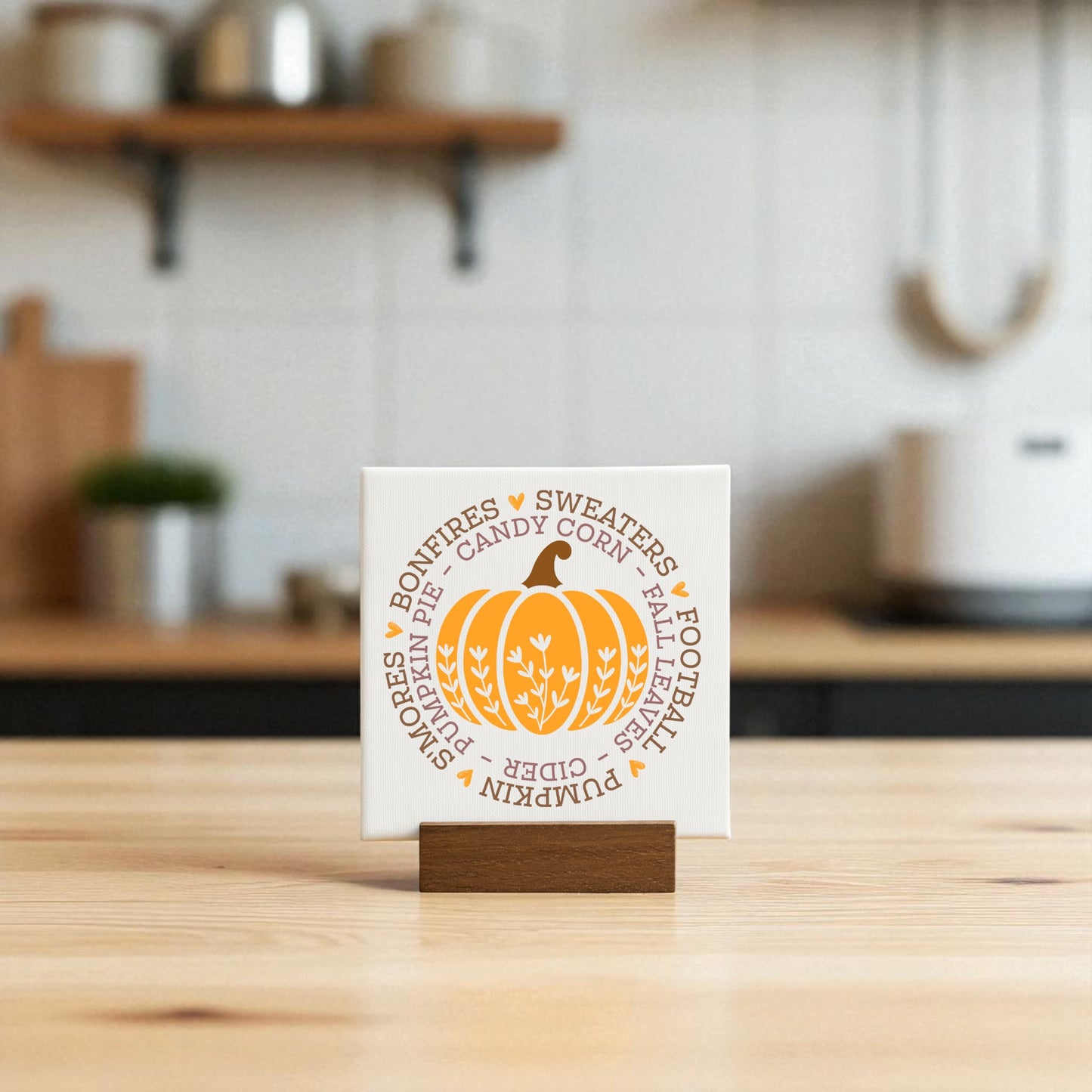 The Mini Fall Sign by Mirabilia Boutique features an orange pumpkin design and cozy words like “sweaters,” “bonfires,” and “cider”—perfect autumn decor for your kitchen or a charming seasonal gift.