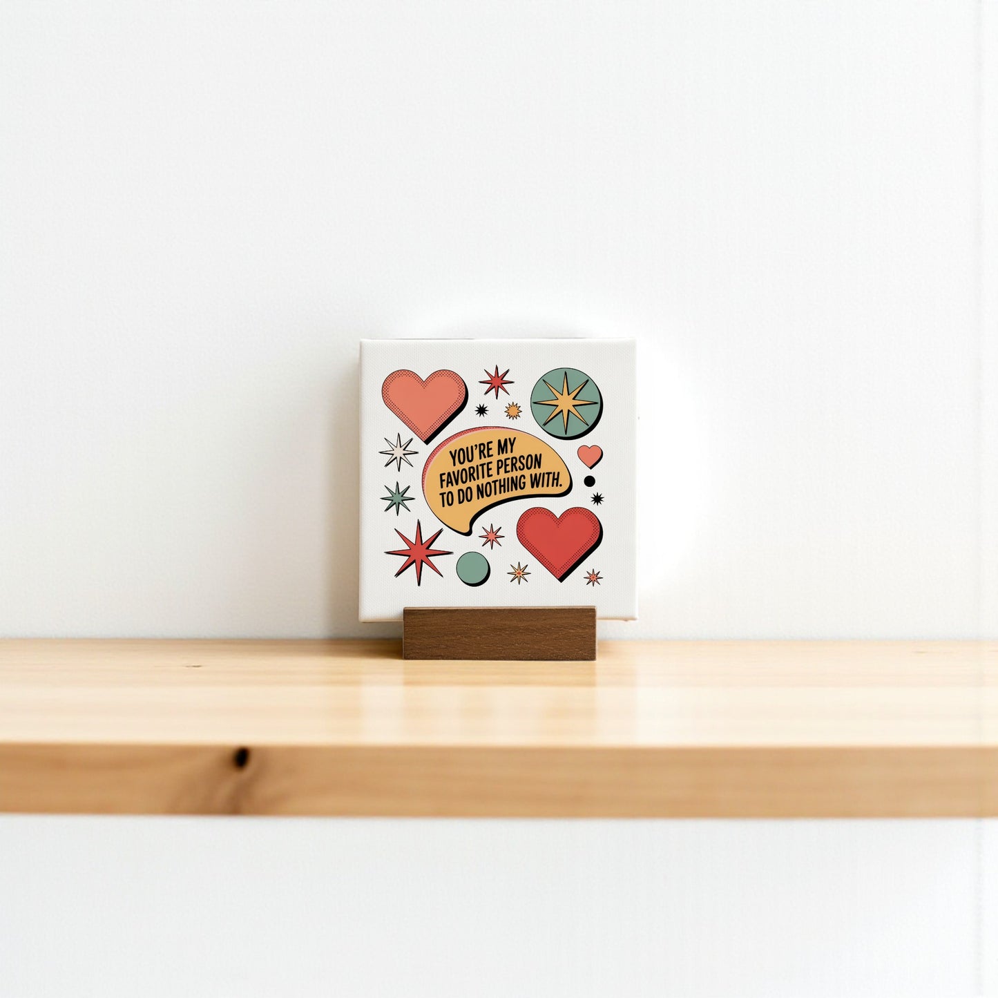 The Retro Mini Love Sign by Mirabilia Boutique features colorful hearts and starbursts with the phrase "You're my favorite person to do nothing with"—a quirky decor piece, perfect as a cute gift for someone special.