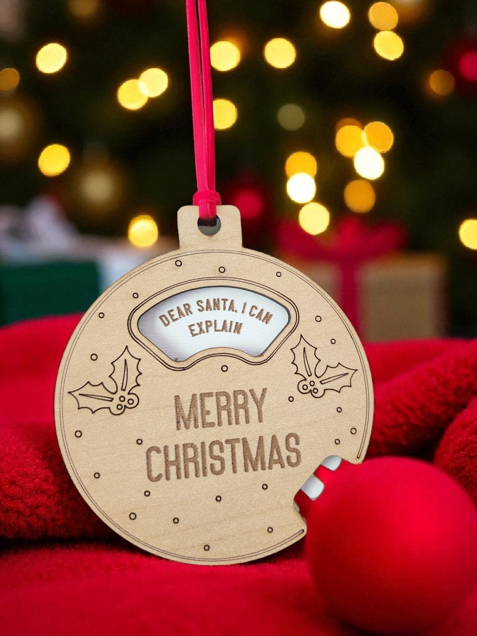 The Mirabilia Boutique Funny Geared Christmas Ornament, "Dear Santa Cookie Spinner," features festive holly designs and playful text, hanging on a red ribbon—an ideal stocking stuffer for the holiday season.