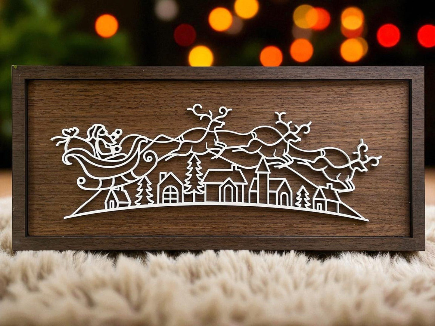 The Rustic Santa Sleigh Sign by Mirabilia Boutique is an 18x8 wooden plaque with a minimalist white outline of Santa’s sleigh over a village, accented by blurred colorful lights for cozy, rustic Christmas decor.
