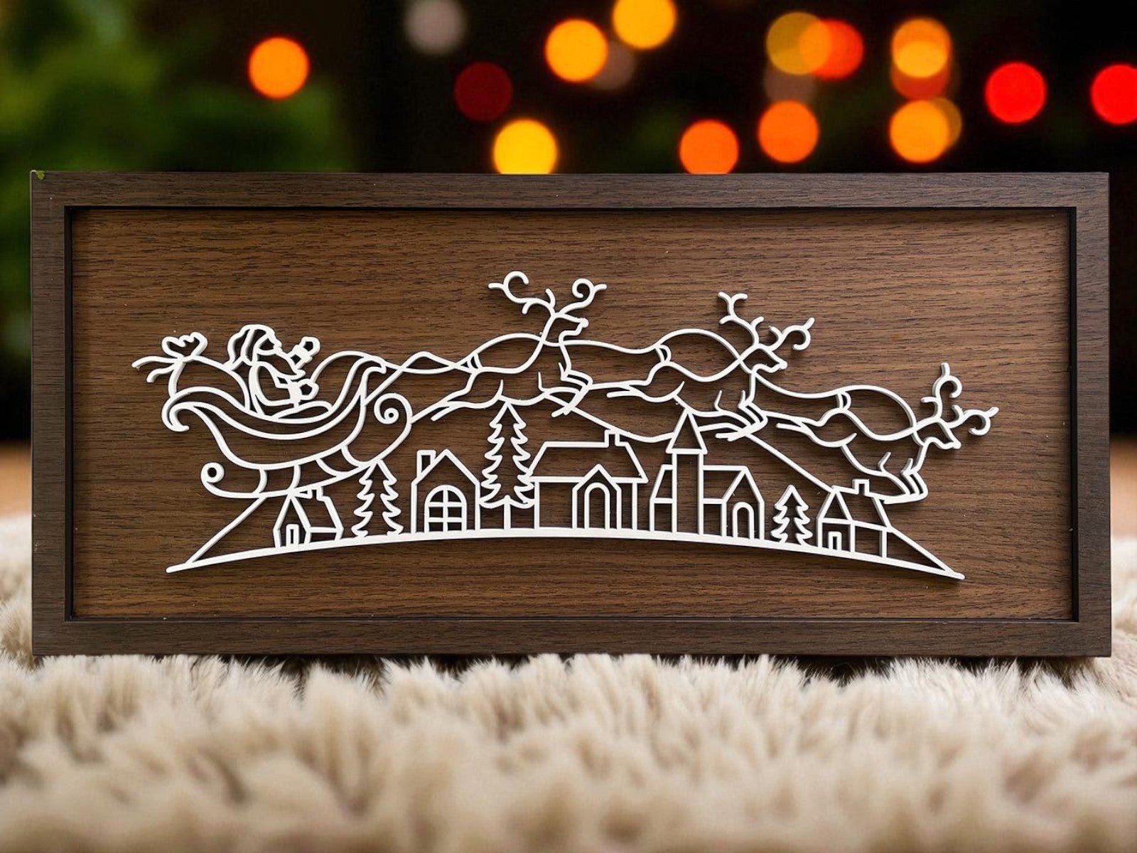 The Rustic Santa Sleigh Sign by Mirabilia Boutique is an 18x8 wooden plaque with a minimalist white outline of Santa’s sleigh over a village, accented by blurred colorful lights for cozy, rustic Christmas decor.