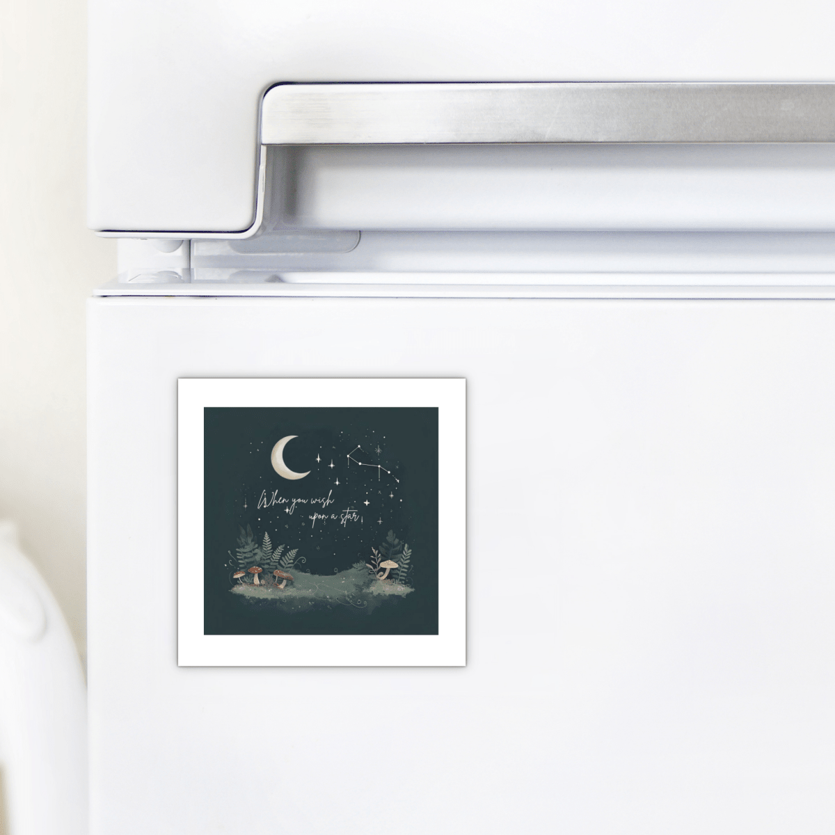 The "When You Wish Upon a Star Woodland Magnet" from Mirabilia Boutique is displayed on a white refrigerator door, featuring a square card with an enchanting night sky, moon, and forest animals—perfect for adding charming celestial decor to your space.