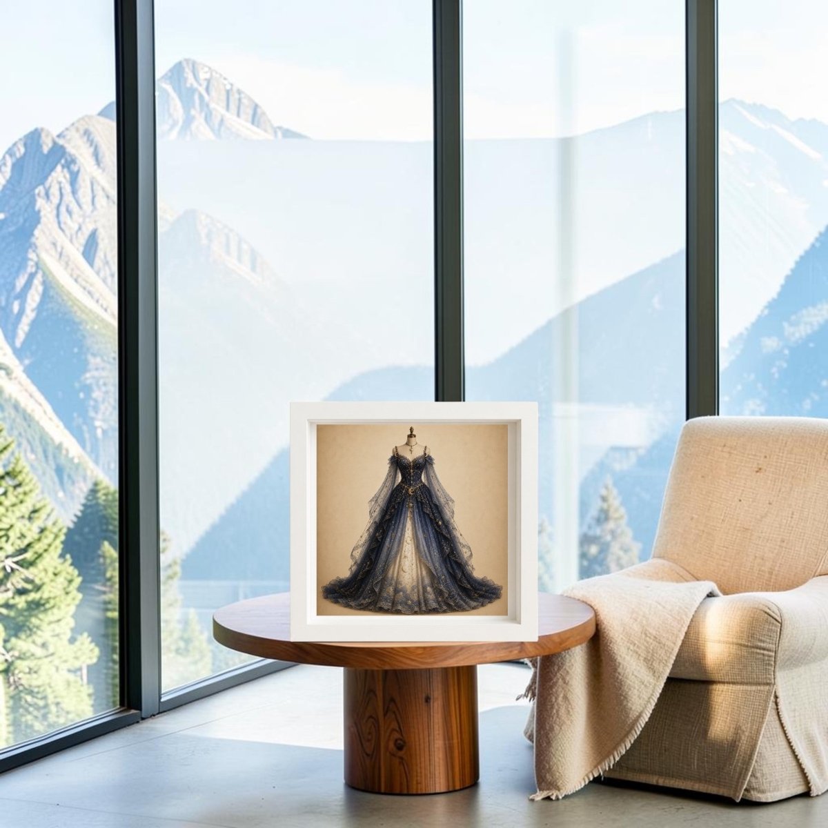 A framed print of “Moonlit Symphony | Curated Couture Artwork” by Mirabilia Boutique, featuring a dark blue ballgown as premium decorative art, is displayed on a round wooden table next to a beige chair, with tall windows offering a scenic mountain view in the background.