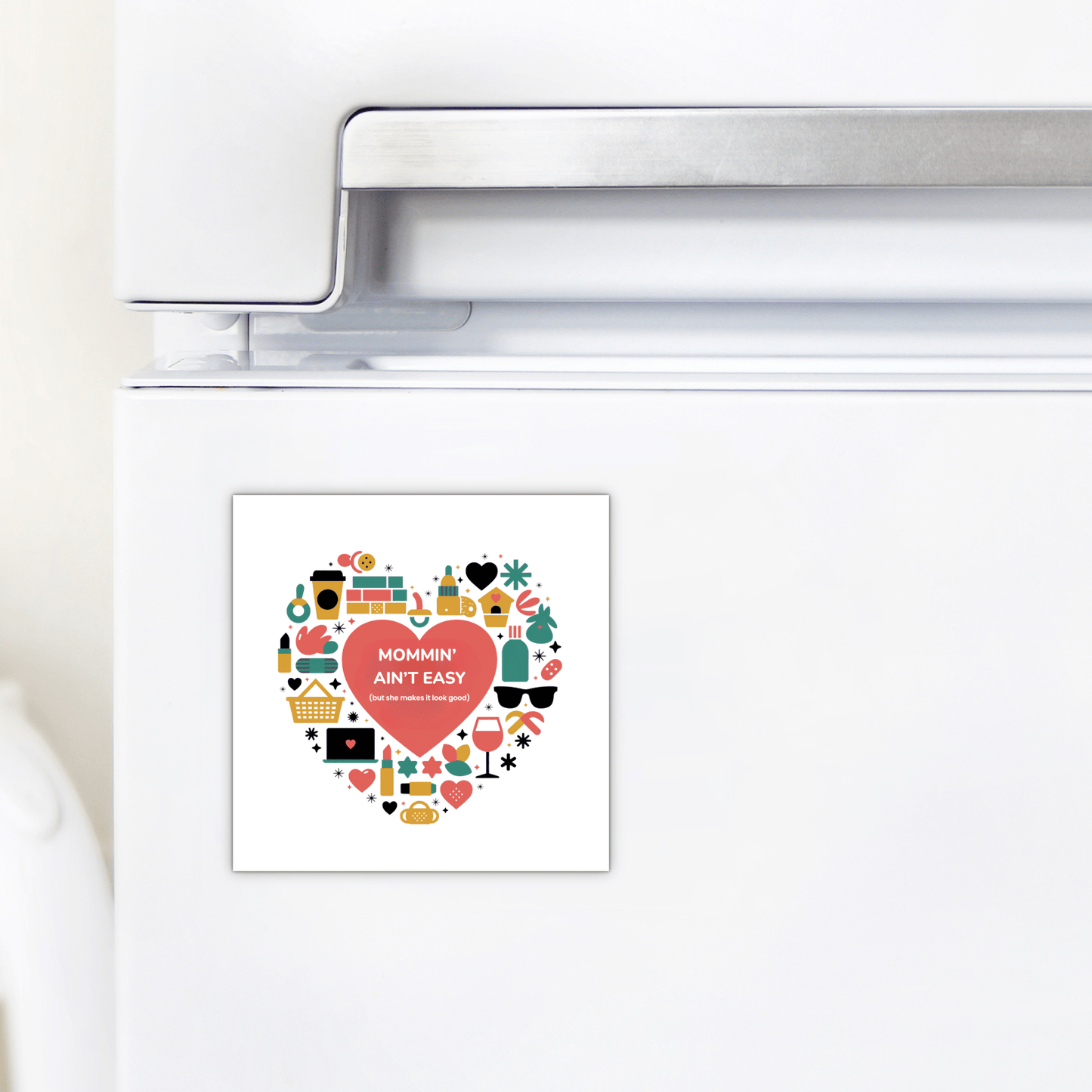 The Mommin’ Ain’t Easy Magnet – Funny Heart Mother's Day Gift by Mirabilia Boutique features a heart with kitchen icons and the phrase “Mommin’ Ain’t Easy”—a charming addition to any fridge and a perfect gift for Mom.