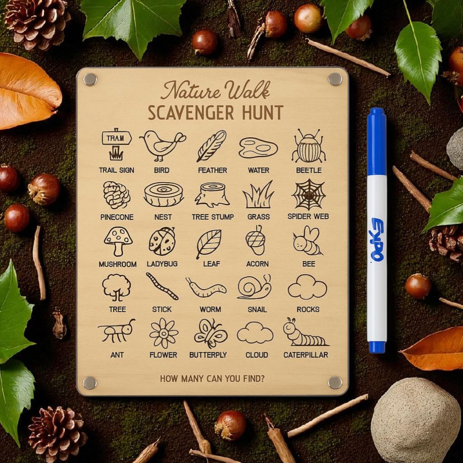 The Mirabilia Boutique Nature Walk Scavenger Hunt is a reusable dry erase board for kids with 24 items, each shown with an icon like a bird or mushroom. Surrounded by leaves and acorns, it includes a blue marker for easy checking.