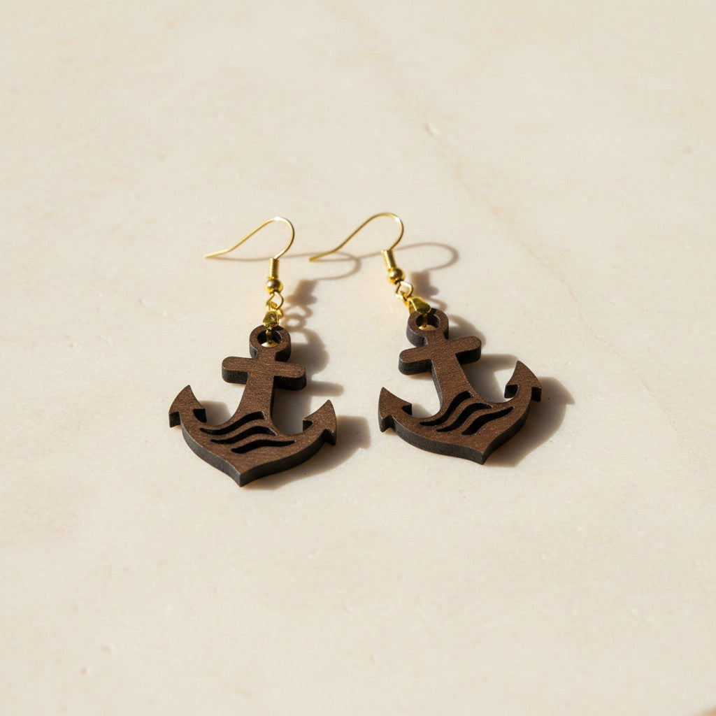 Mirabilia Boutique's Anchor Earrings | Lasercut Walnut Wood feature anchor designs and gold hooks, shown on a light beige surface—ideal for nautical jewelry enthusiasts.