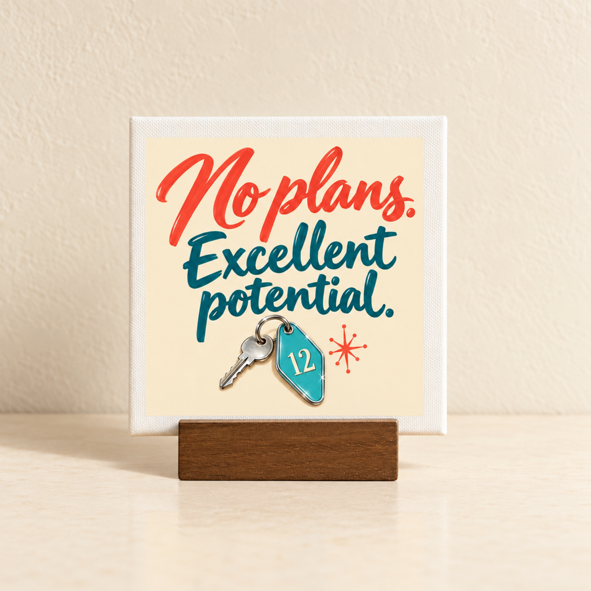 Mirabilia Boutique No Plans, Excellent Potential Mini Sign | Chrome & Starlight featuring a small square motivational decor on a wooden stand with an attached metal key and a blue motel-style keychain numbered 12.