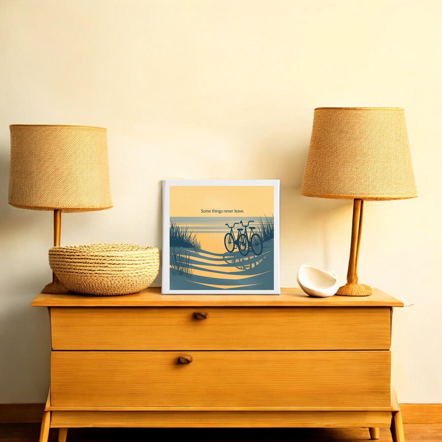 A wooden dresser with two lamps, a woven basket, and a decorative bowl. Centered is Mirabilia Boutique's Some Things Never Leave Canvas – Coastal Memory Art, perfect as a sentimental gift or for beach wall decor.