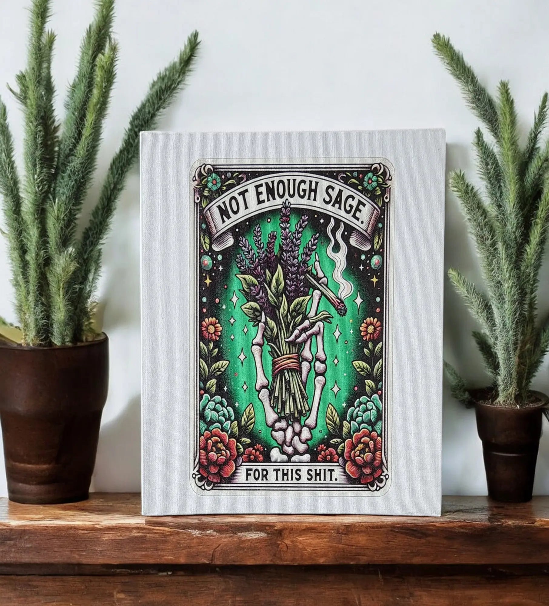 This humorous gift features a framed illustration from Mirabilia Boutique titled "Humorous Sage Quote Wall Art Print for Home or Office Decor." It showcases a charming bundle of sage with flowers against a green background, accompanied by the witty text, "Not Enough Sage for This Shit." Flanked by potted plants, it makes for an eye-catching piece on any shelf.