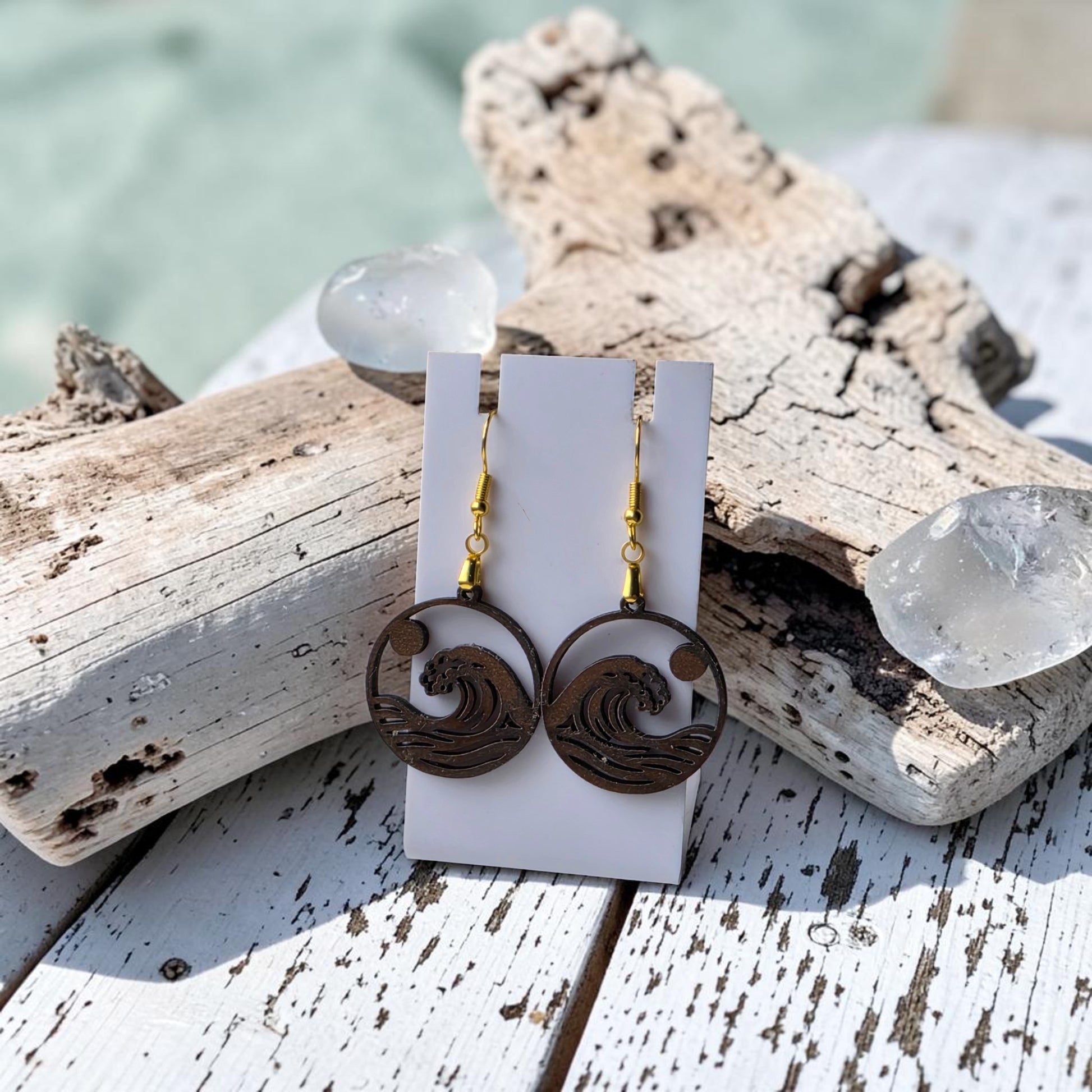 The Sunrise Wave Earrings by Mirabilia Boutique feature a wave design lasercut from walnut wood, displayed on a white card and perfect as coastal jewelry for ocean lovers.
